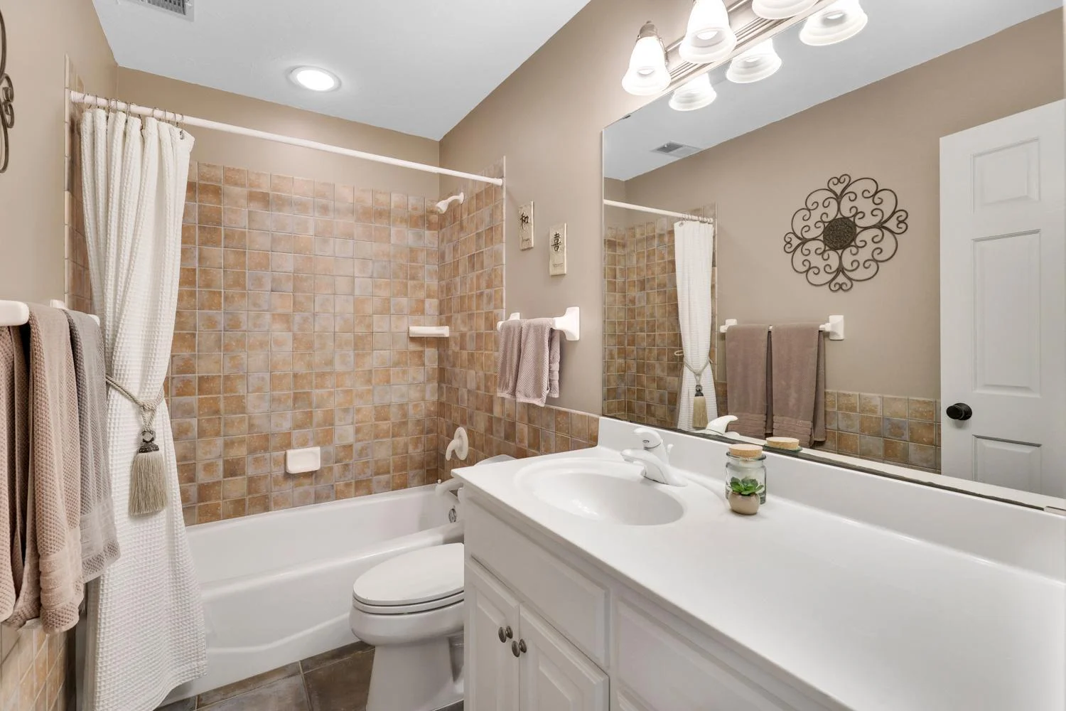One of two lower-level full baths with full ceramic and stone finishes and oversized vanities