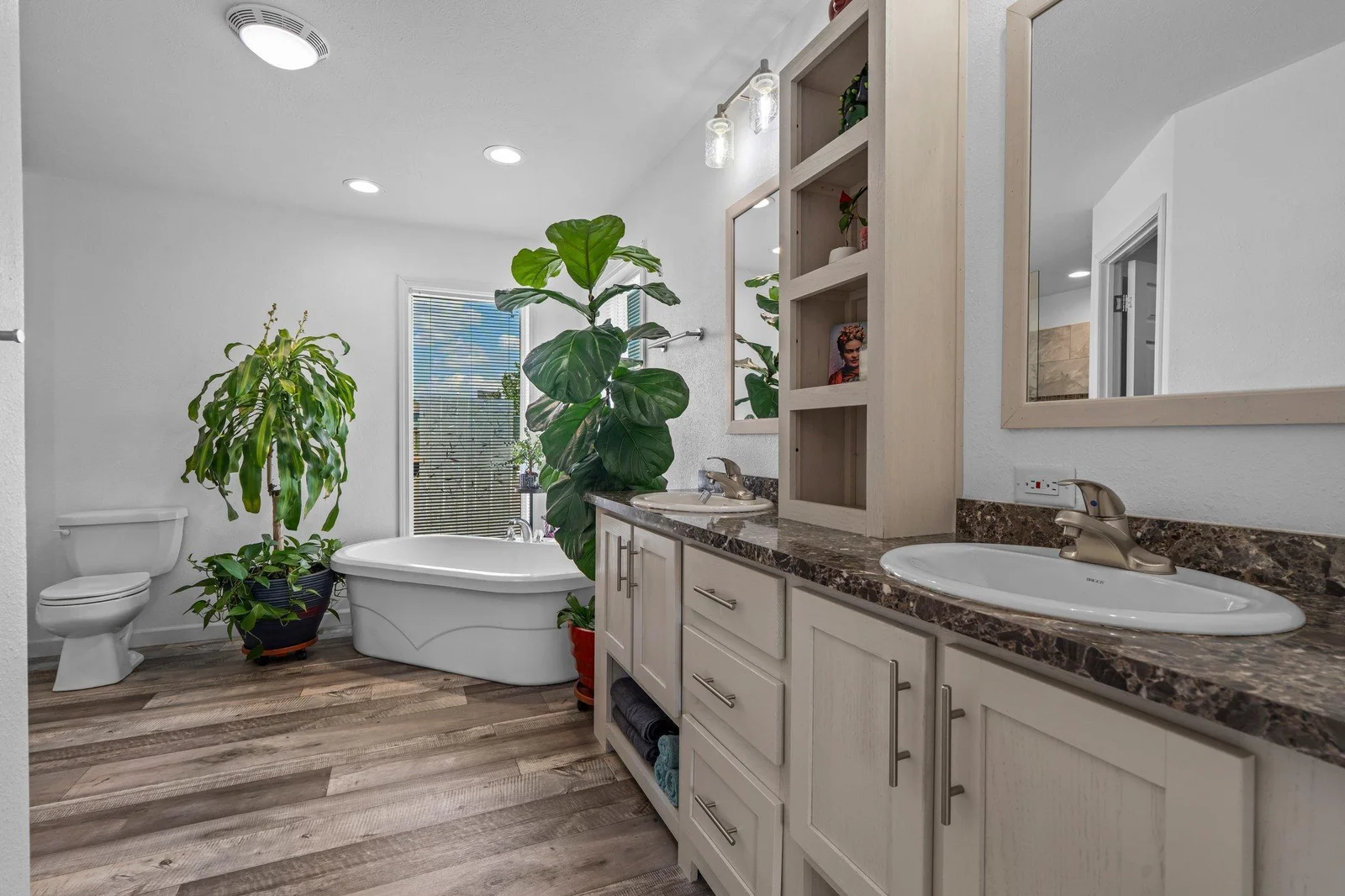 The attached en suite bath is spa-like, complete with a deep soaking tub, a 6x4 walk-in tiled shower, and a double vanity with abundant cabinet and counter space.