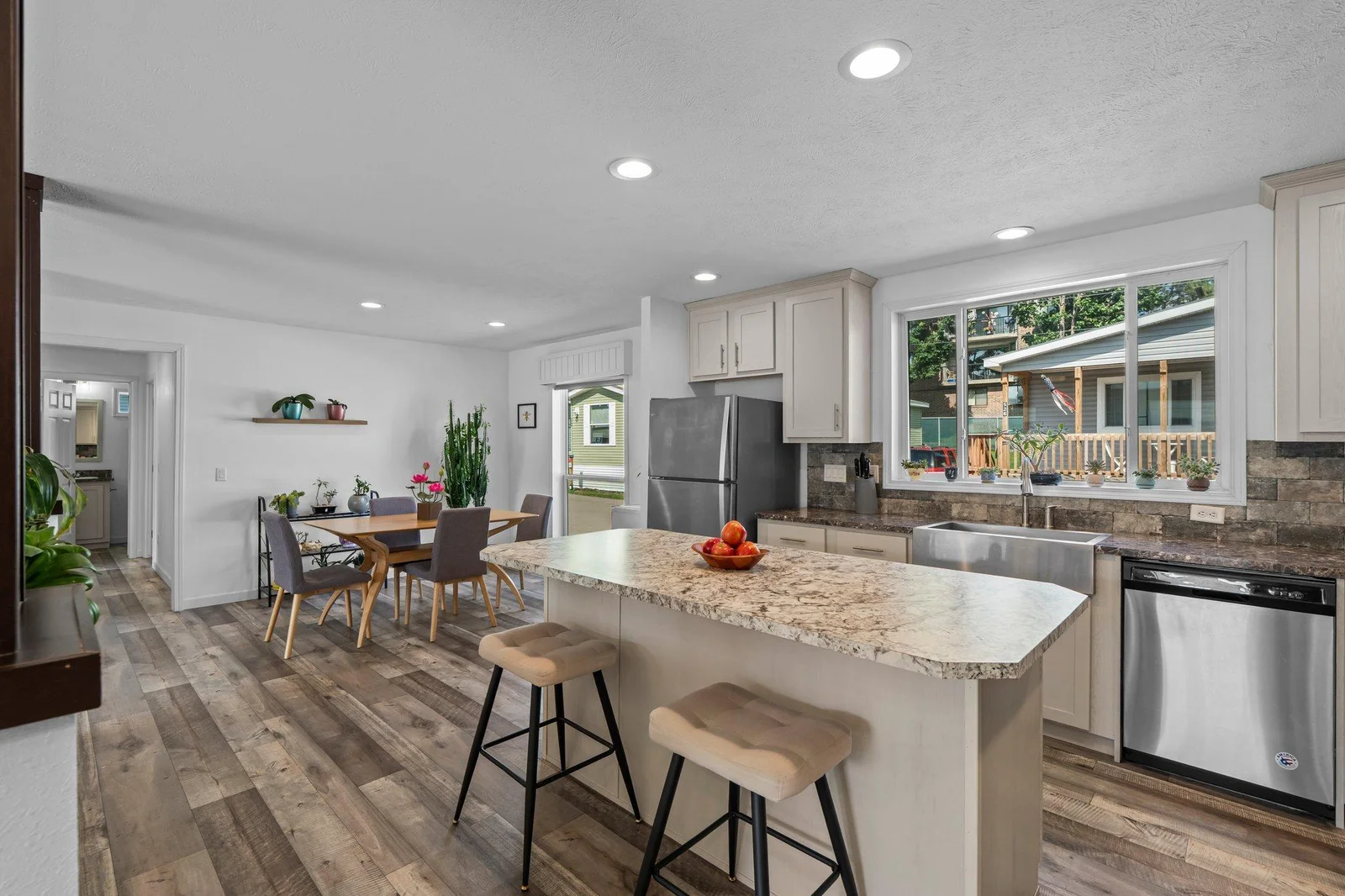 A large center island with breakfast bar seating and built-in storage is ideal for casual meals or gathering. The kitchen’s functional layout and bright ambiance make it both a practical workspace and a welcoming hub of the home.