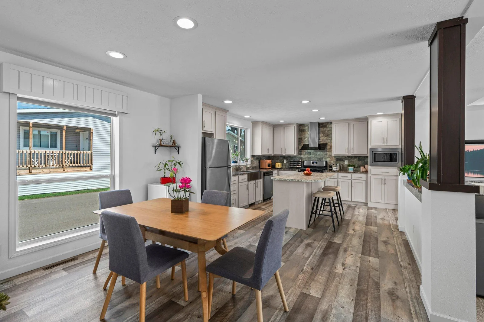 Just off the kitchen is a designated dining area featuring a large window that frames views of the yard.
