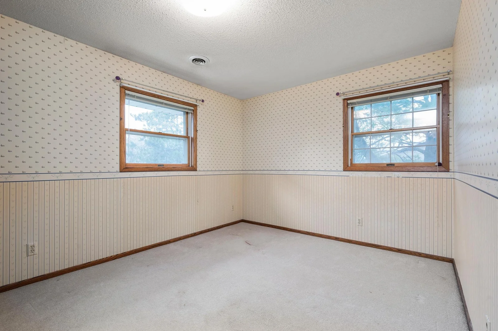 The second bedroom on the upper level has a large closet and treetop views of the yard.