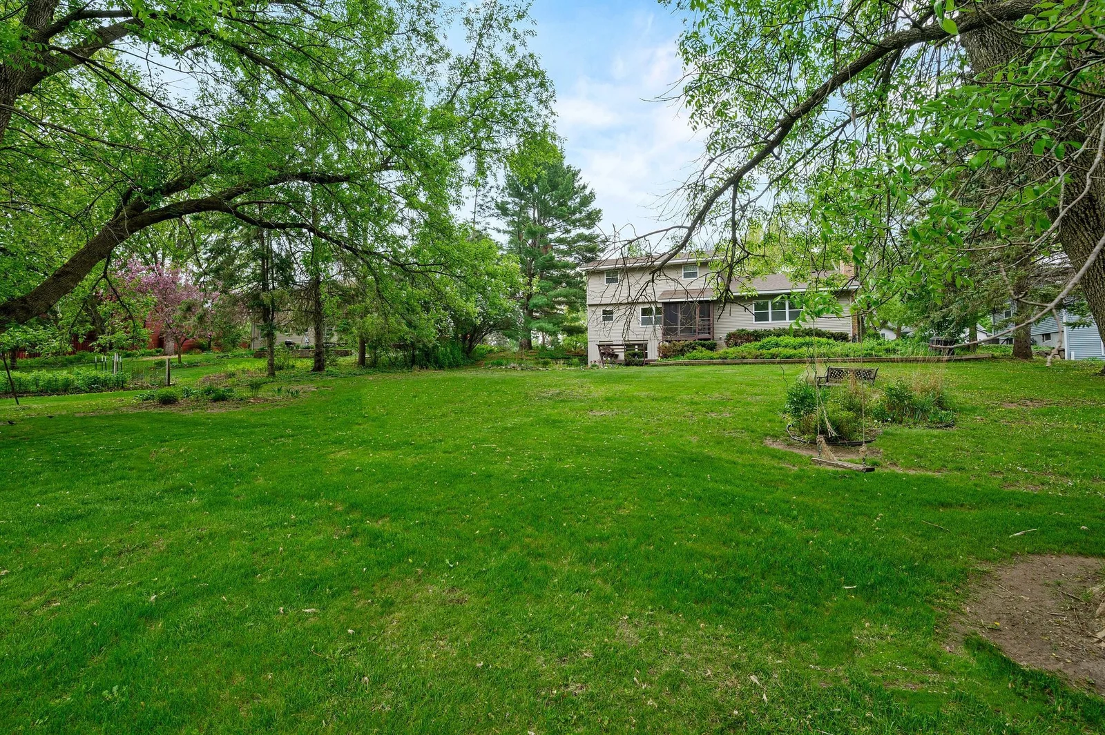 Garden-lined yard with mature shade trees