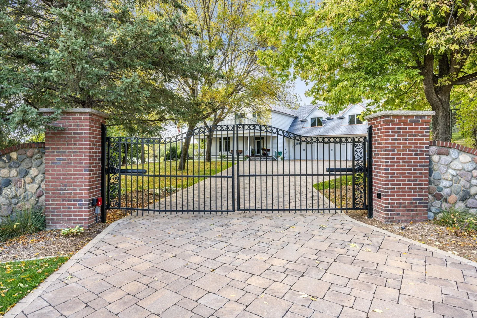 As you arrive, a stately gated entrance framed by brick and stone welcomes you to this exceptional property. The heated paver driveway sets the tone for a home where every detail has been thoughtfully designed and impeccably maintained.