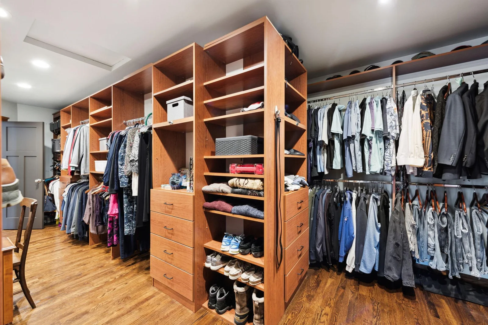 This expansive walk-through closet offers custom built-ins, abundant storage, and organization for every season, complementing the luxury and functionality of the primary suite.