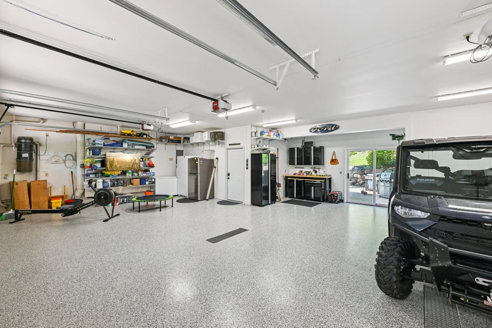 The expansive 1,000+ sq ft heated garage offers in-floor heat, epoxy flooring, floor drain, and ample space for vehicles, lake toys, or a workshop for all four seasons that Minnesota has to offer.