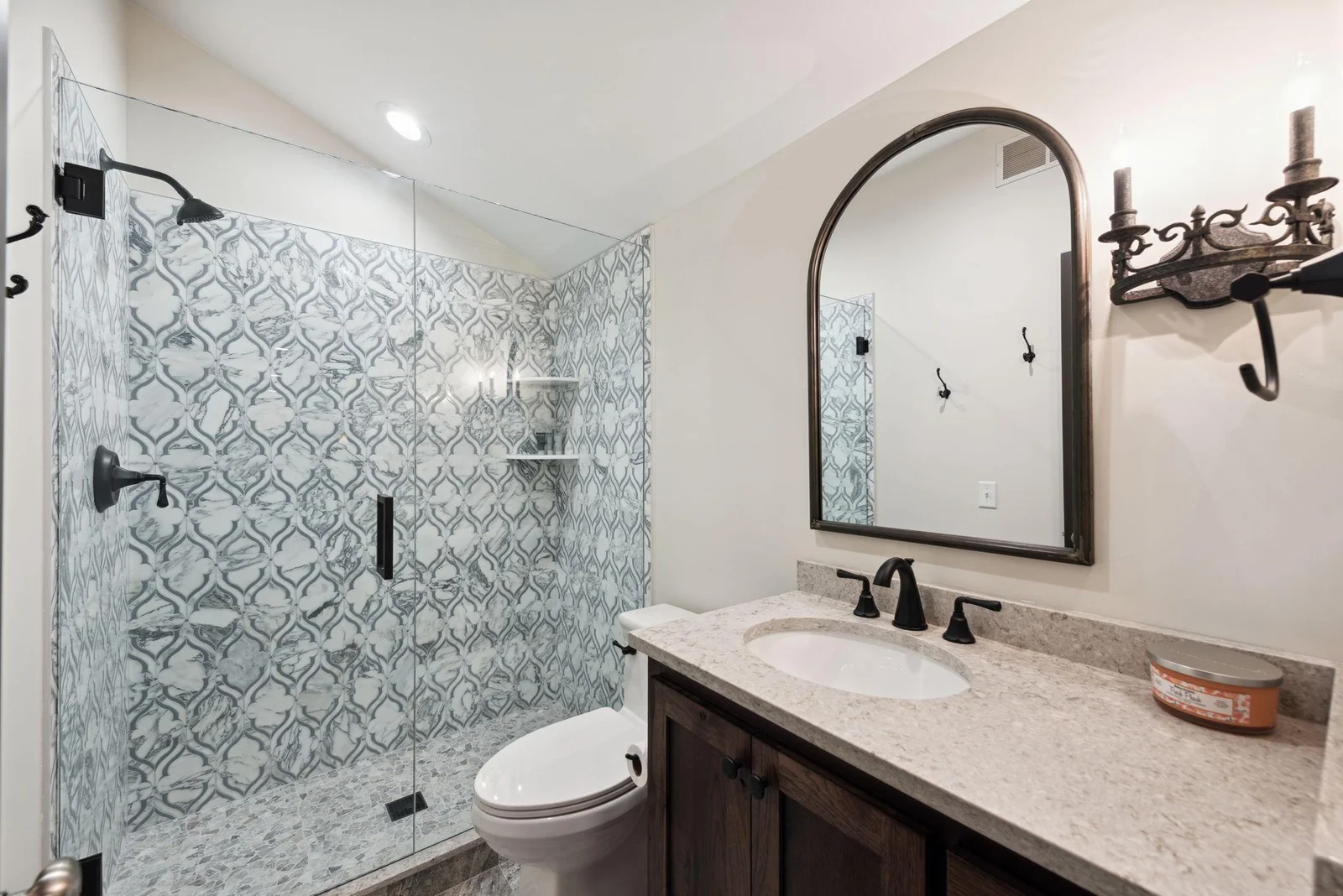 Located just off the second level living room, this elegant three-quarter bath features a stunning walk-in shower with designer tile and a rich wood vanity with stone countertop.