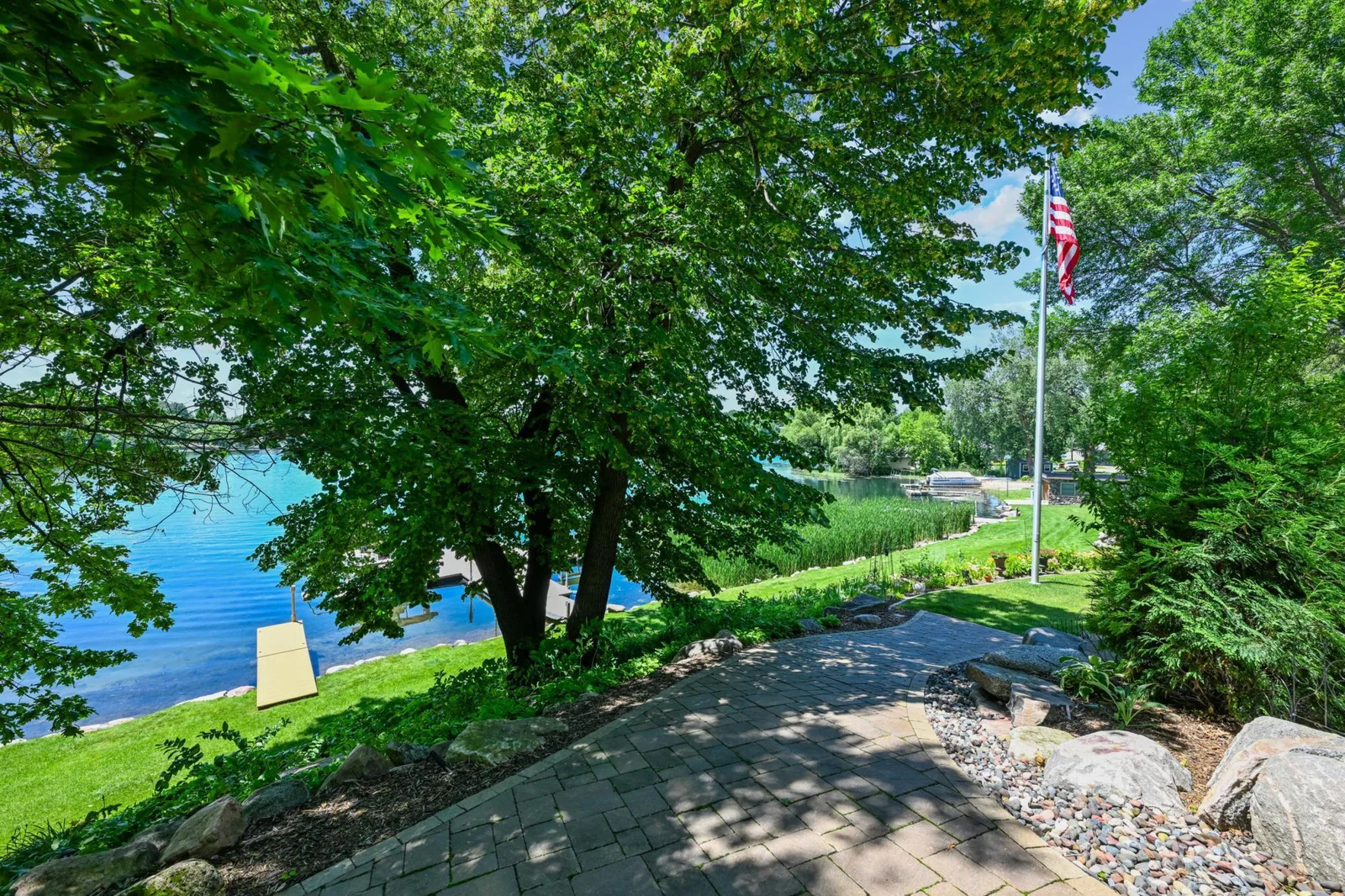 Follow the beautifully landscaped paver walkway down to the crystal-clear shoreline, where the private docks and peaceful views of Lake Sylvia await.