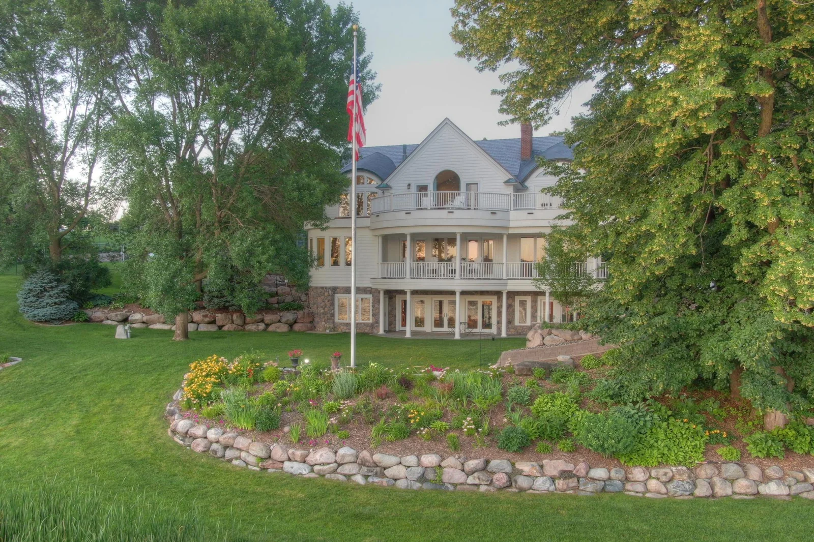 Surrounded by mature trees, lush perennial gardens, and boulder-lined landscaping, this beautifully maintained property feels like your own private lakeside park.