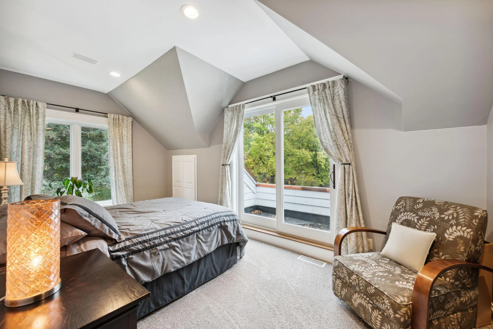 One of two charming bedrooms in this private wing, featuring a walkout balcony with serene views to the south of the drive, gardens, pathways, and landscape.