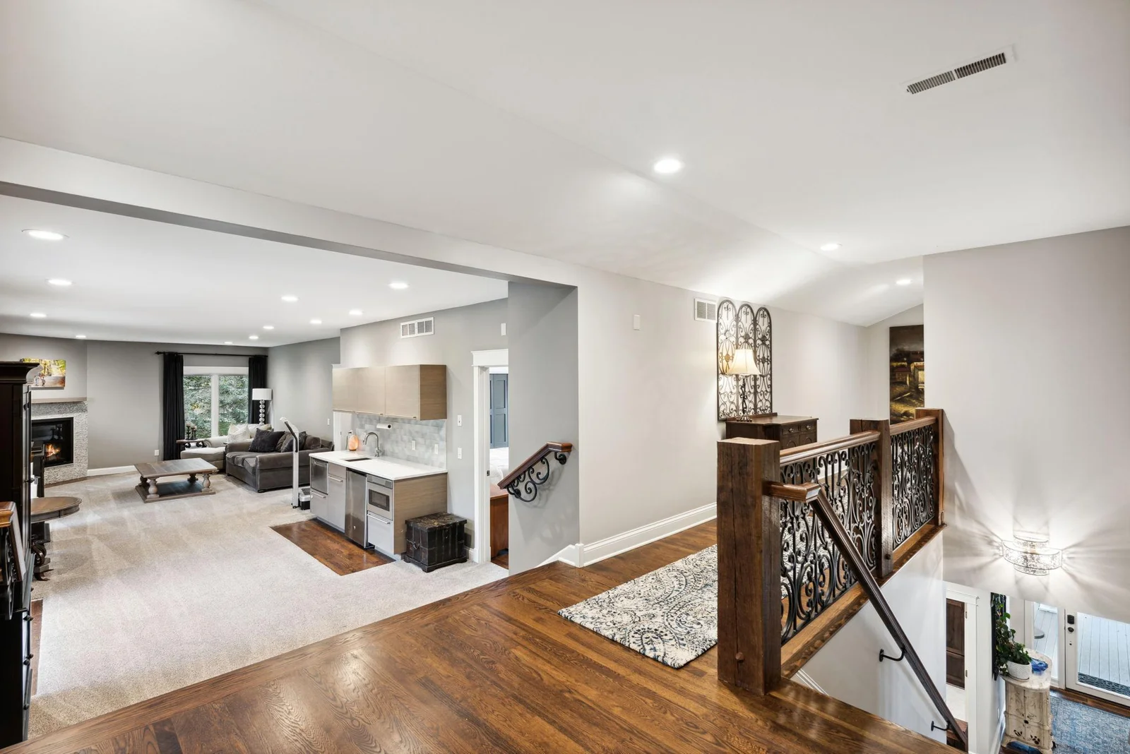 The open layout flows into the upper level, featuring a spacious living room with wet bar—perfect for entertaining. Once a private apartment above the garage, this area has been seamlessly integrated into the home’s luxury design.