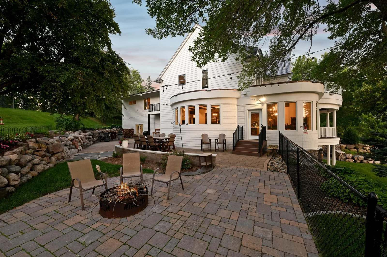Step outside the kitchen to a spacious paver patio with built-in fire pit and multiple seating areas, perfect for outdoor dining and gathering with loved ones while taking in peaceful views of Lake Sylvia.