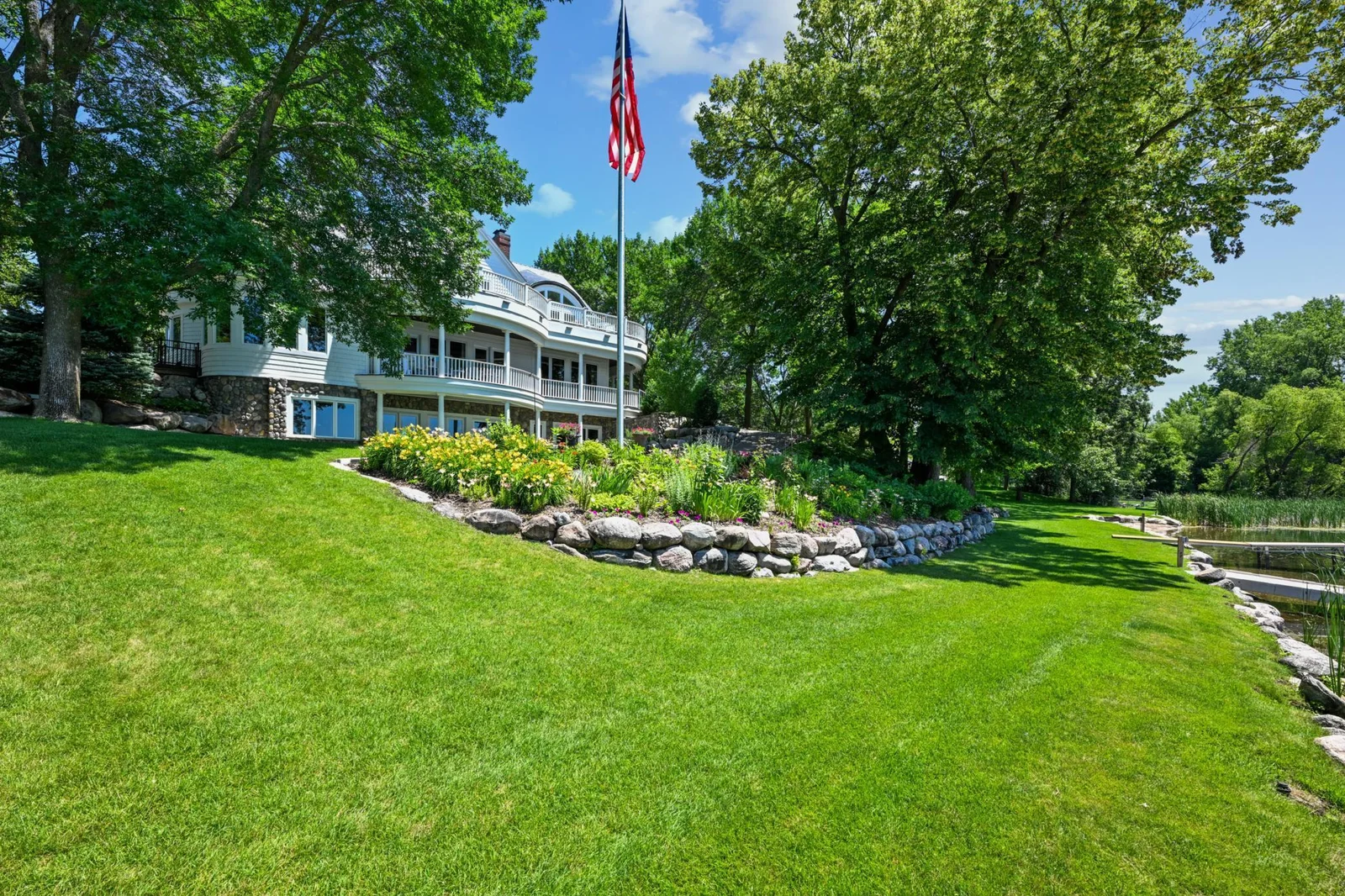A grand American flag waves proudly over this exceptional lakeshore estate, where timeless architecture meets manicured grounds and a gently sloping lawn to the water’s edge. Celebrate lake living on the grand shores of West Lake Sylvia in Annandale.