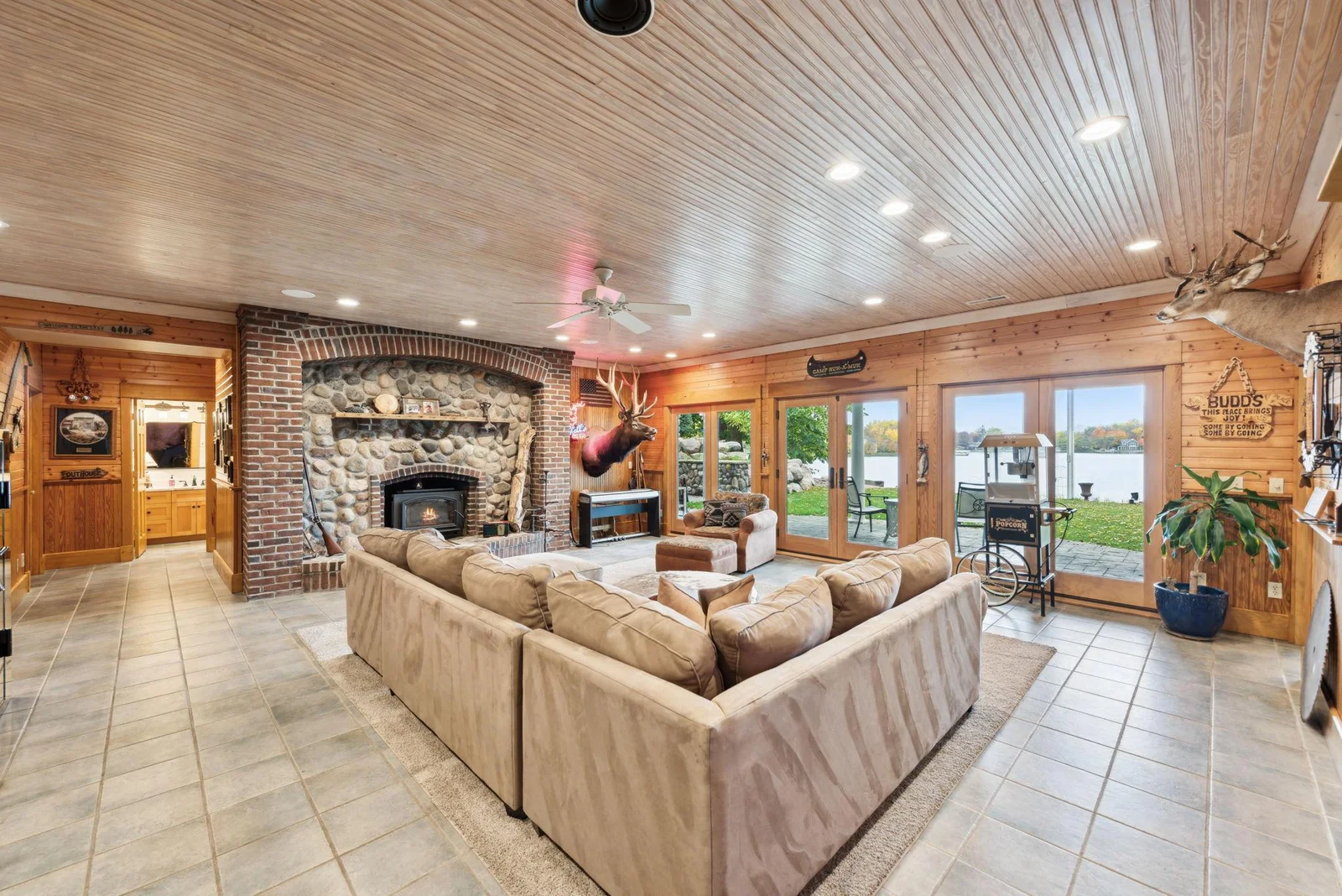 Anchored by a stunning wood-burning fireplace with stone and brick surround, this lower-level space brings cozy “up north” charm to lakeside living.