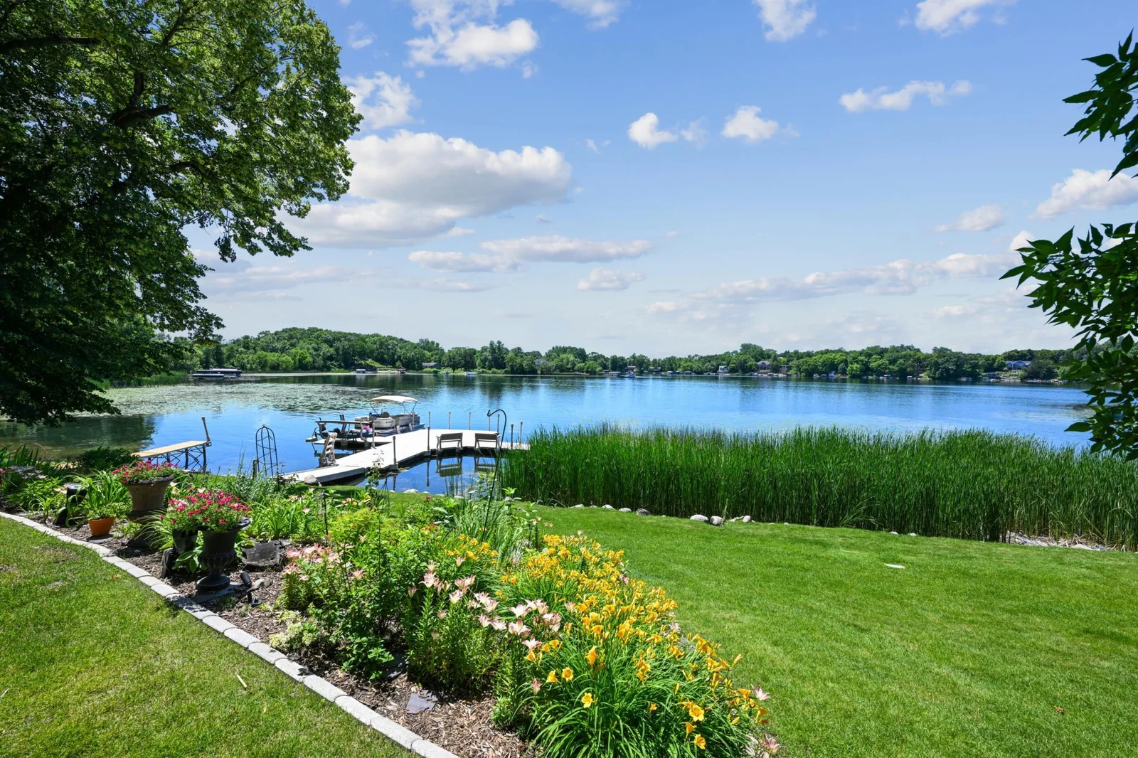 The lush lawn, vibrant perennial gardens and stunning views create a serene park-like setting on the shores of Lake Sylvia.