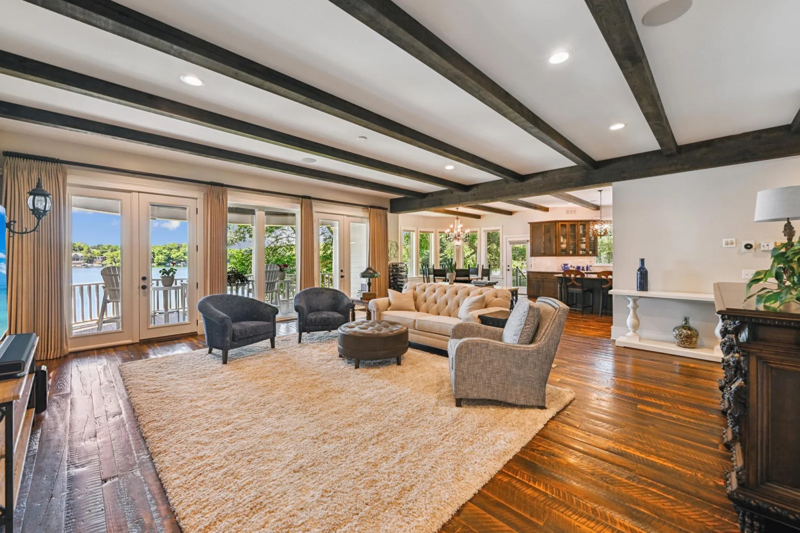 The open-concept main level spans over 2,100 sq ft, filled with natural light from a stunning wall of lakeside windows offering breathtaking views of West Lake Sylvia.
