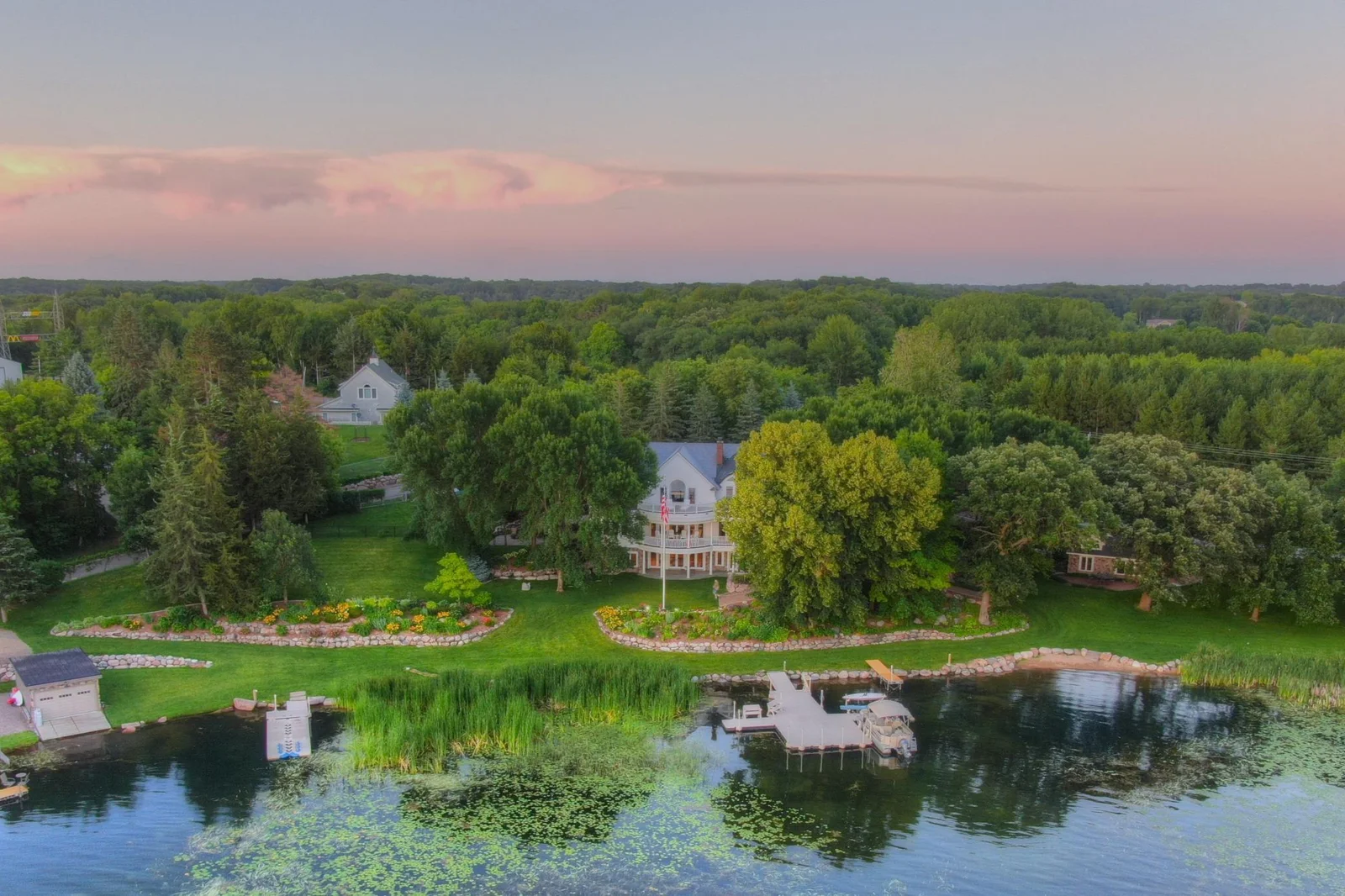A stunning aerial perspective of this private West Lake Sylvia estate, showcasing its expansive shoreline, beautifully manicured grounds, guest cottage, and dual docks. Surrounded by mature trees and natural beauty has unmatched tranquility.