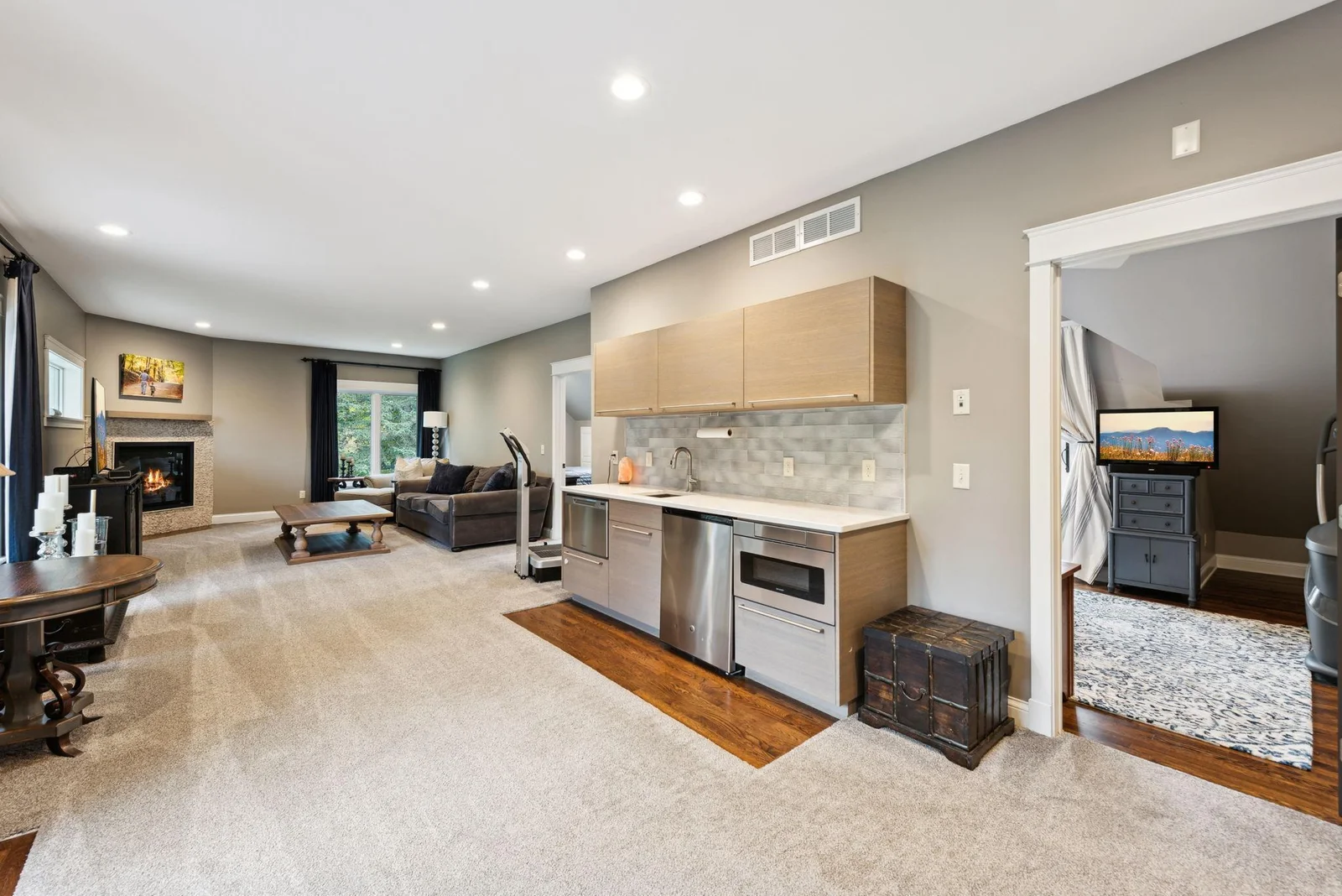 The upper-level wet bar is perfect for entertaining, complete with a sink, microwave, beverage fridge, and dishwasher all seamlessly integrated into a sleek, modern design.