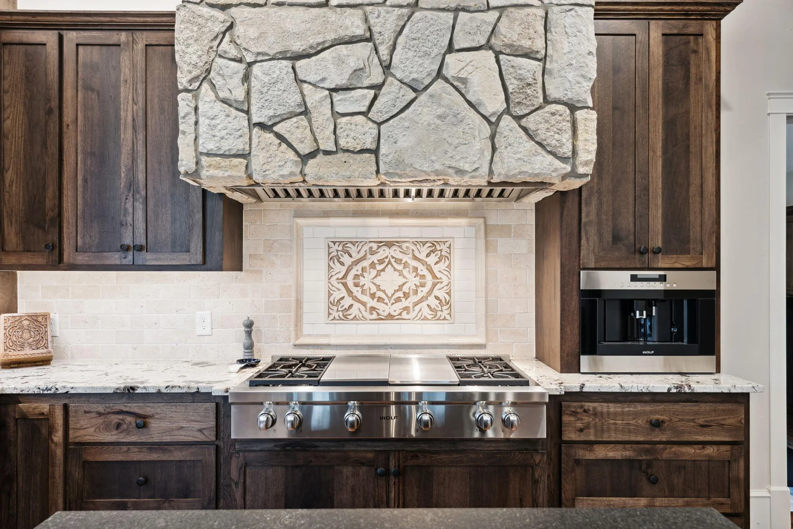 This stunning 2019 kitchen remodel features commercial-grade Wolf appliances, including a built-in coffee system, custom stonework, and rich wood cabinetry designed for luxury, function, and style.