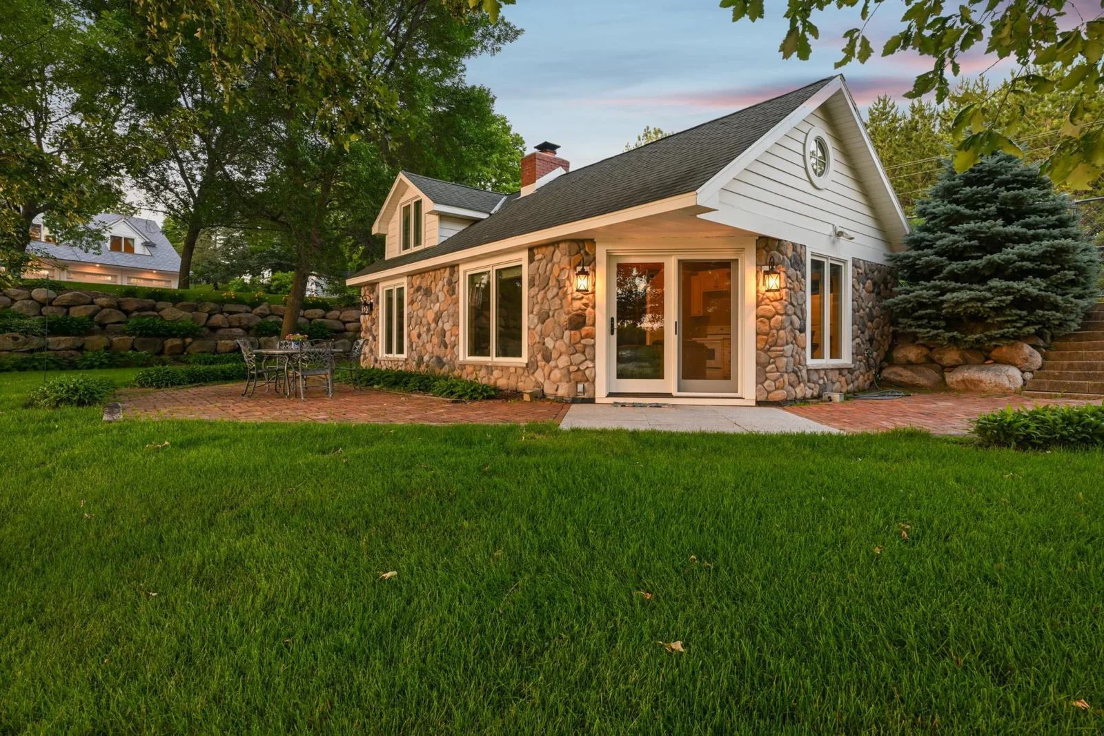 Charming stone guest cottage featuring a cozy interior, private entrance, and brick patio perfect for hosting visitors or long-term guests. The guest cottage has its own separate septic system.