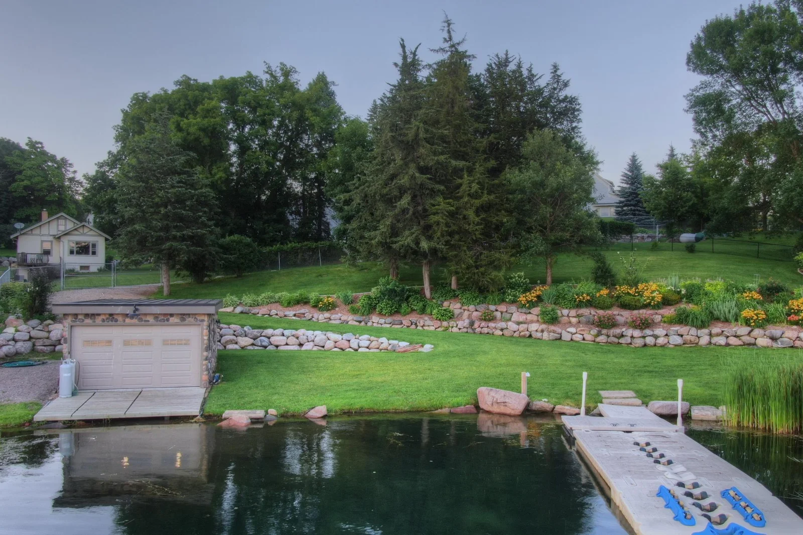 The gently sloping lawn leads to calm, clear waters of Lake Sylvia perfect for fun in the water or enjoying peaceful lakeside moments. A rare blend of function and beauty on this exceptional lakeshore property.