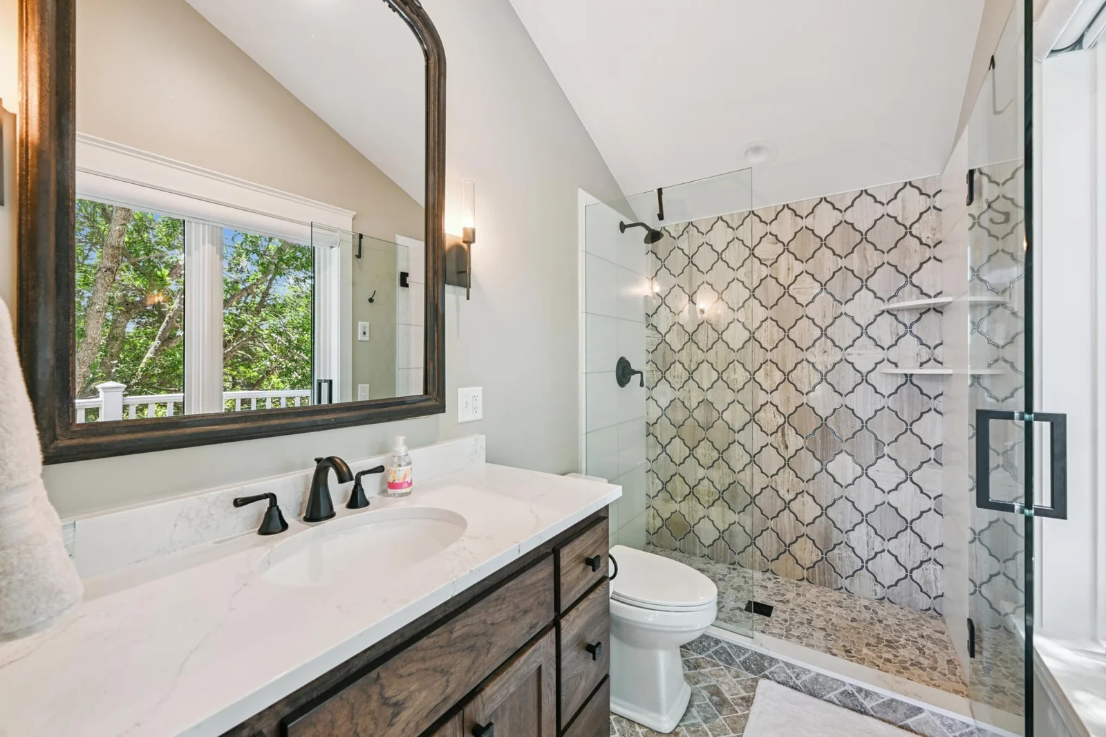 This private en-suite bath features a stylish tile walk-in shower and spacious vanity. The luxury touches that could easily make this bedroom feel like a primary suite in most homes.