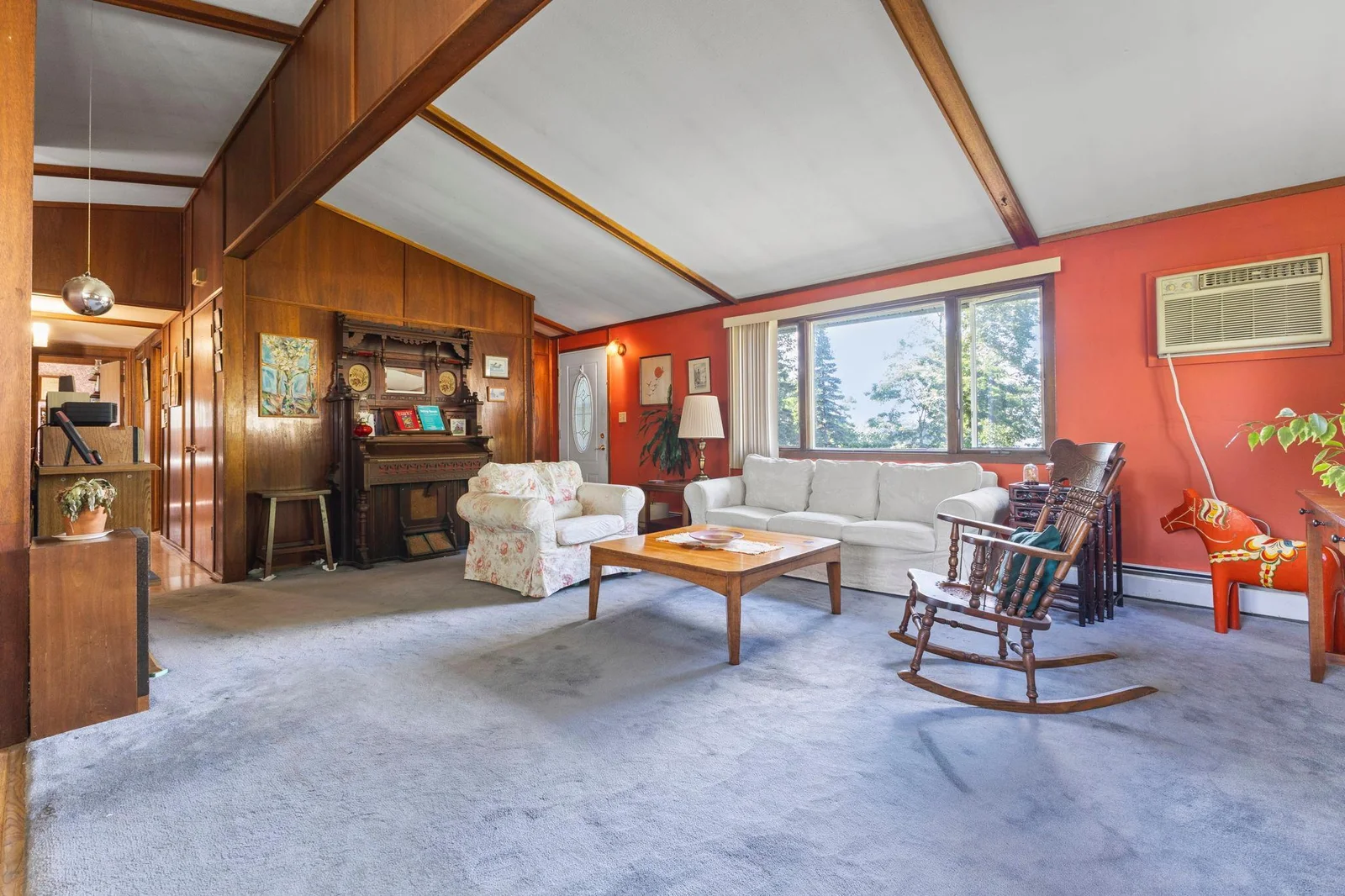 Wonderful living room with beautiful wood paneled walls and exposed timbers with a great view of the lake!