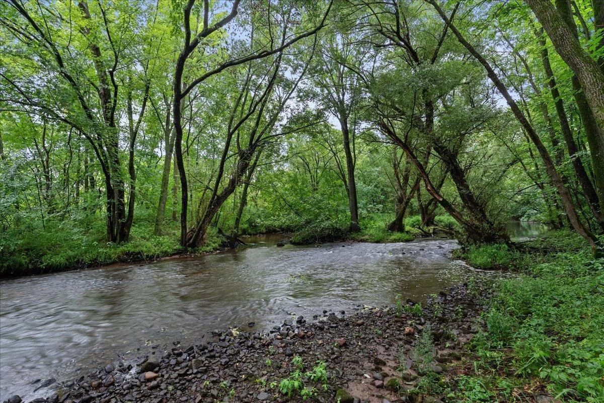 Enjoy the sound of the gentle river flowing over the rocks every day from this riverfront retreat!