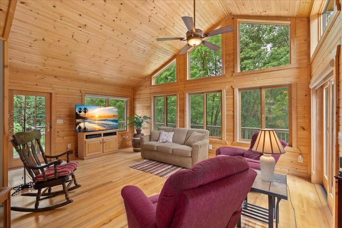 Living room is FULL of windows allowing natural light and nature views right into the home.