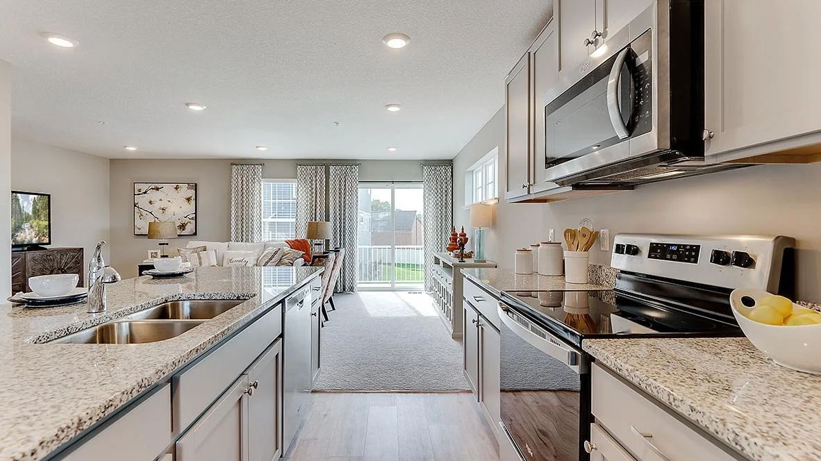 The kitchen looks out to the large deck located off the family room. Model picture shown. Colors and finishes may vary. Subject address is an interior unit. Exterior unit photos shown.