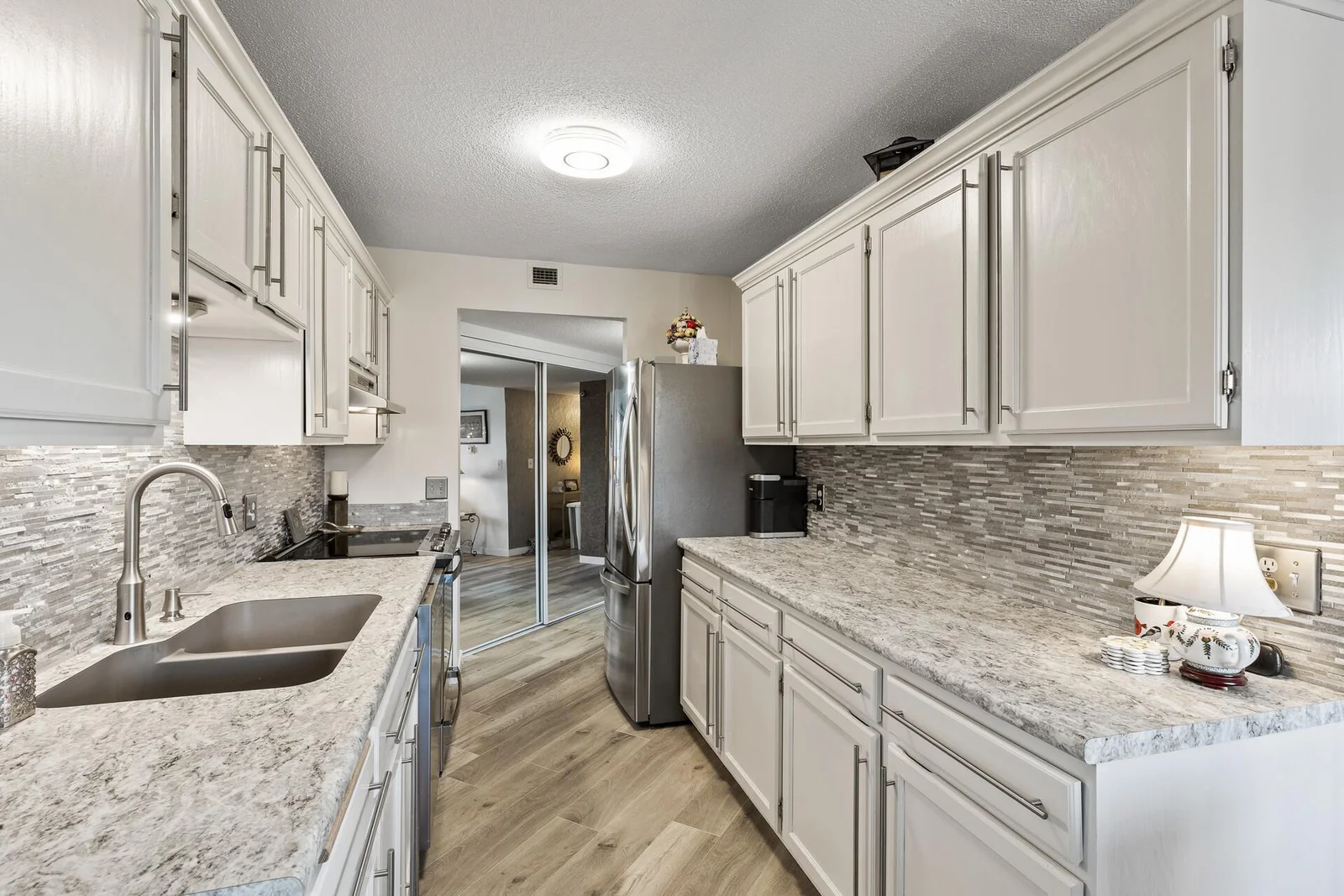 Beautiful remodeled kitchen! New counters, sink, tile back splash and high-end stainless steel appliances. Enjoy the enameled cabinets!
