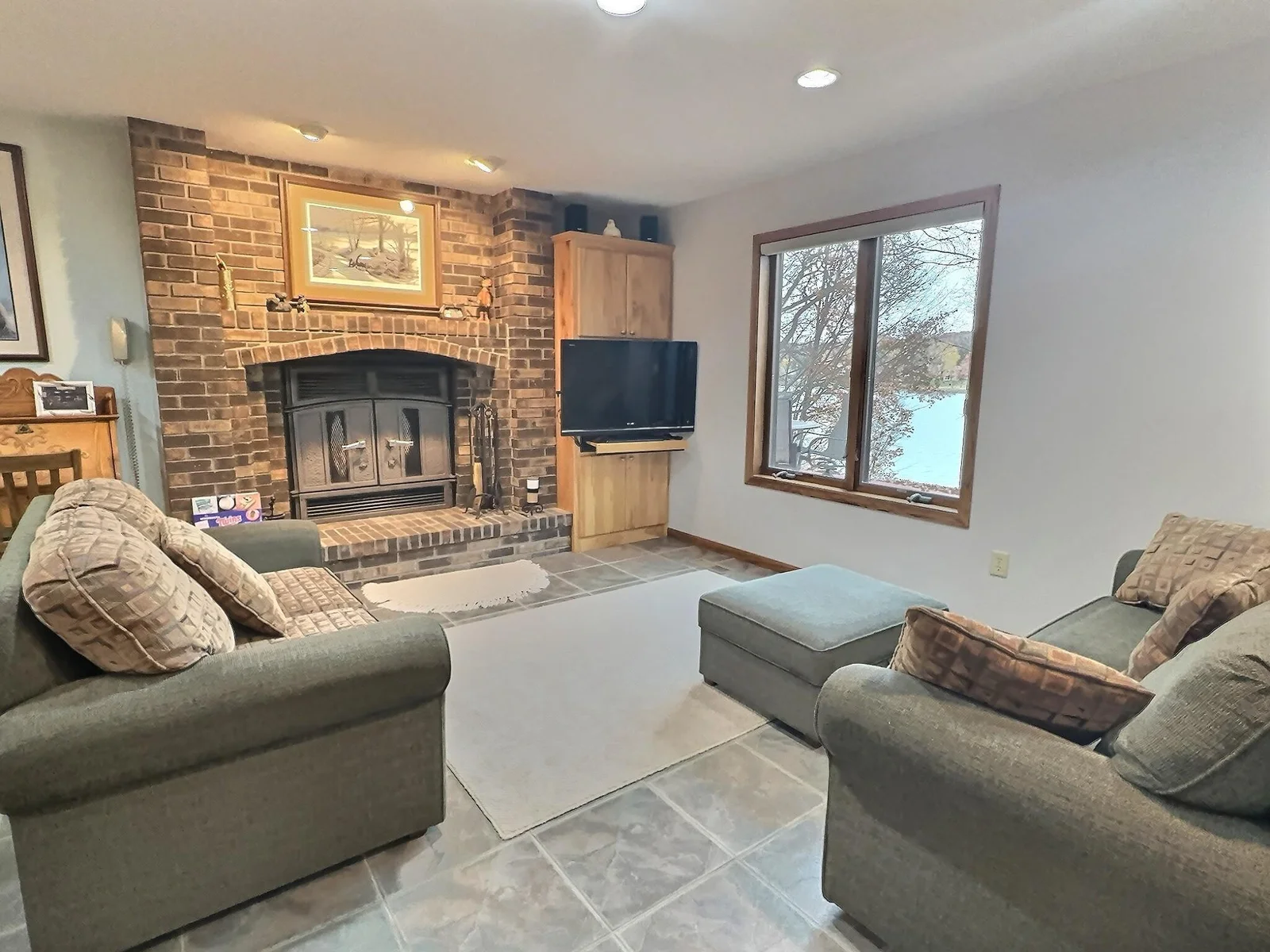 The lower level is the heart of the home.  Ceramic tile throughout this open gathering space.  You will love cozying up to this wood burning fireplace during the cooler months.