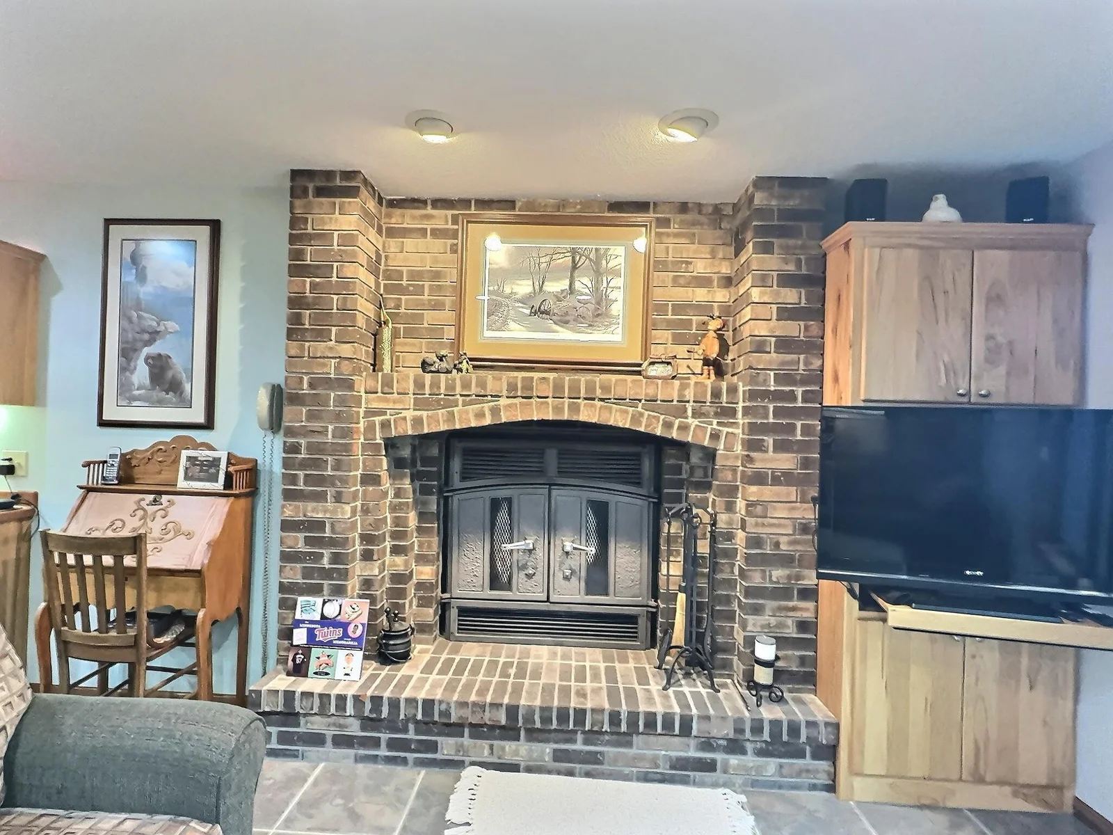 A close-up view of the fireplace and another built in oak cabinet.