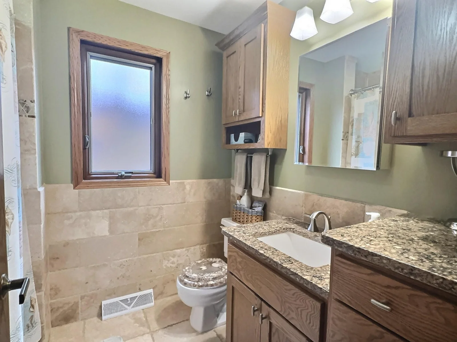 The main floor full bathroom has updated cabinets and granite countertops.  Tile flooring and tub/shower surround.