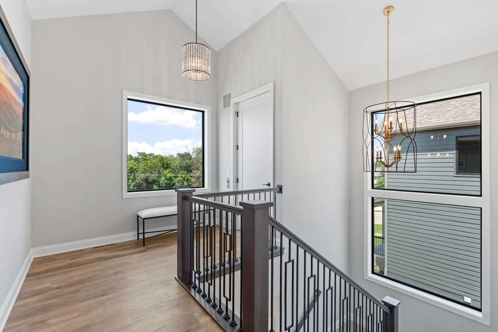 Main level entry offers open staircase that features maple newel posts and railings w/ decorative iron balusters. Vaulted ceilings and large windows that offer an abundance of natural light