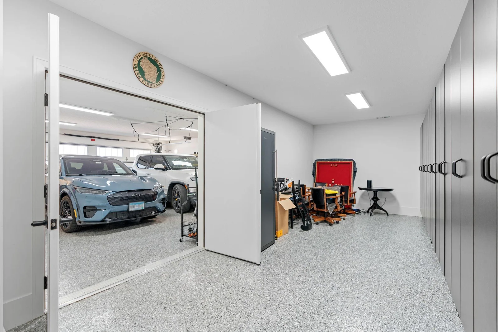 2 - Car Garage features epoxy finish flooring, finished walls and ceiling. French doors open to into the Storage Room that features epoxy finished floors, finished walls and ceiling and dog wash station!