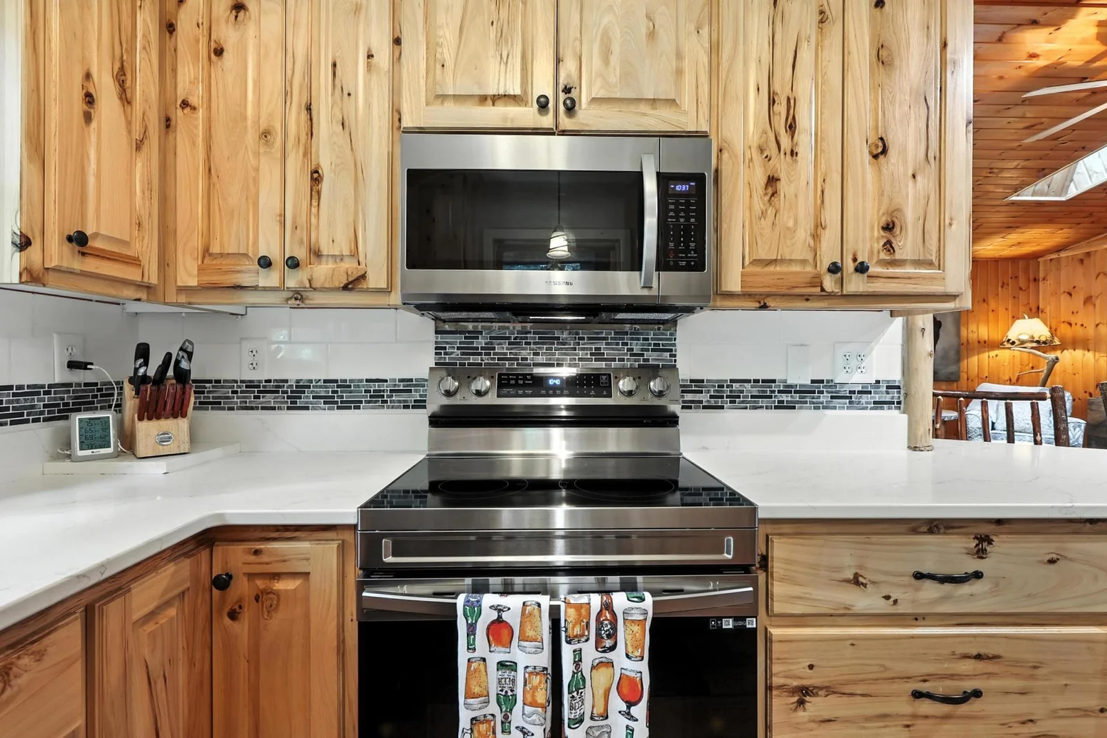 Close-up of the cooking area highlights the modern stainless range and microwave, ample counter space, and artisan cabinetry—combining style and function.