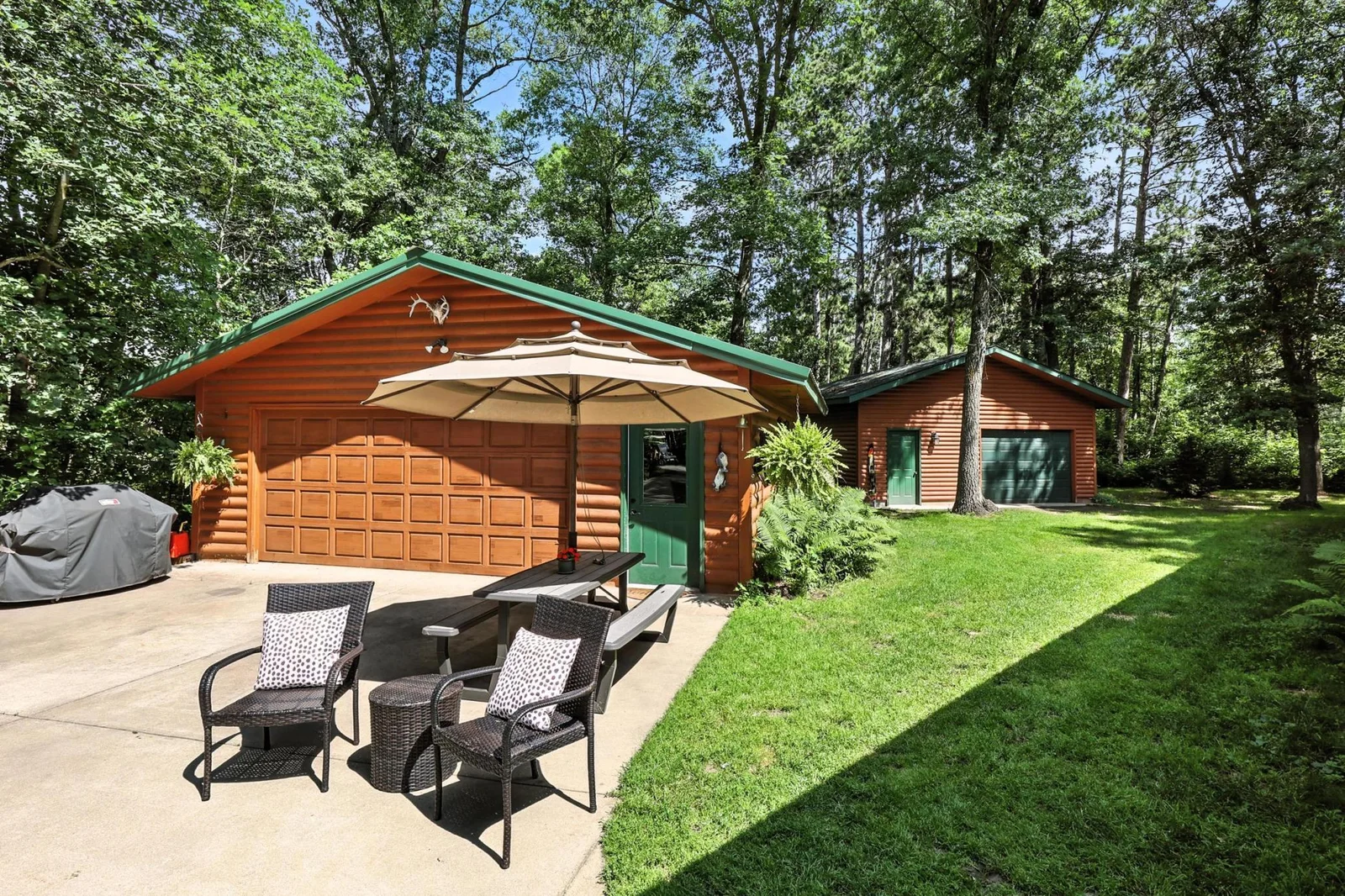 Spacious 26x28 heated garage with an adjacent 24x24 detached garage offers ample room for vehicles, storage, and outdoor toys.