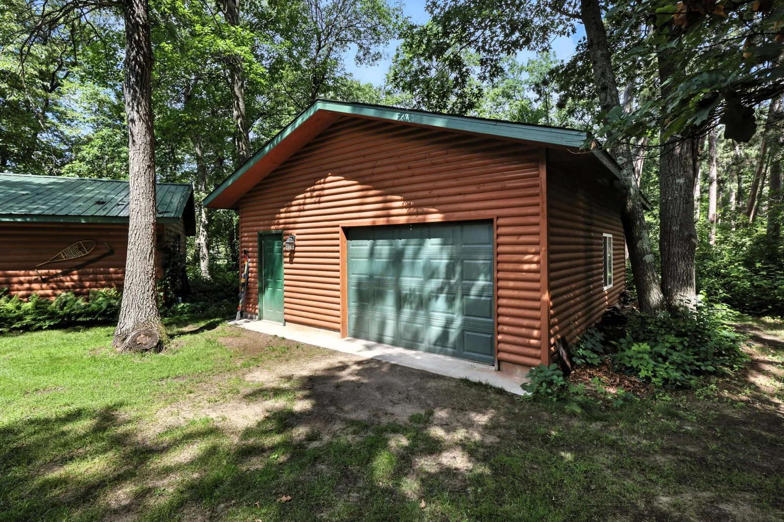 Tucked in the trees, this large storage garage features easy-access doors and blends seamlessly into the wooded setting.