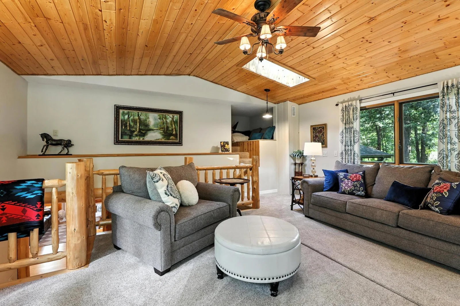 Expansive upper level living room with plush carpet and ample natural light.