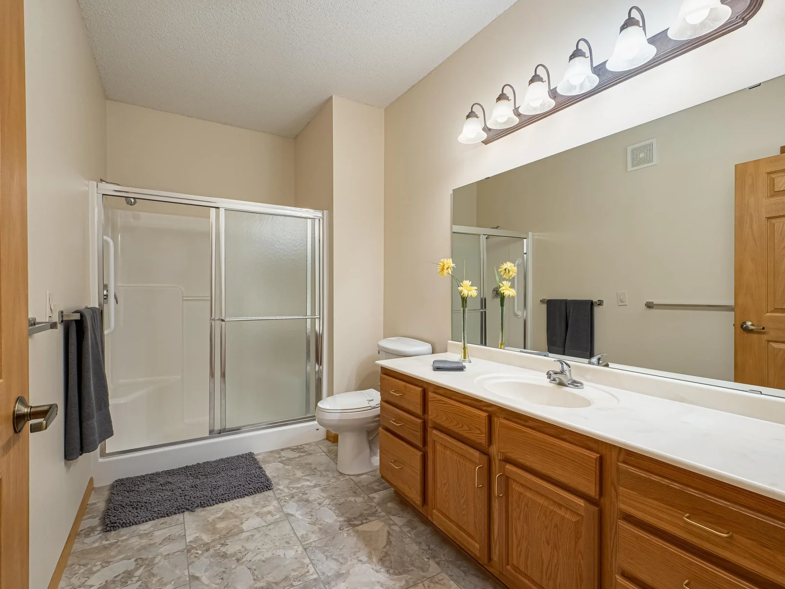 Primary suite bathroom with comfort height toilet, grab bars and ceramic tile floors.