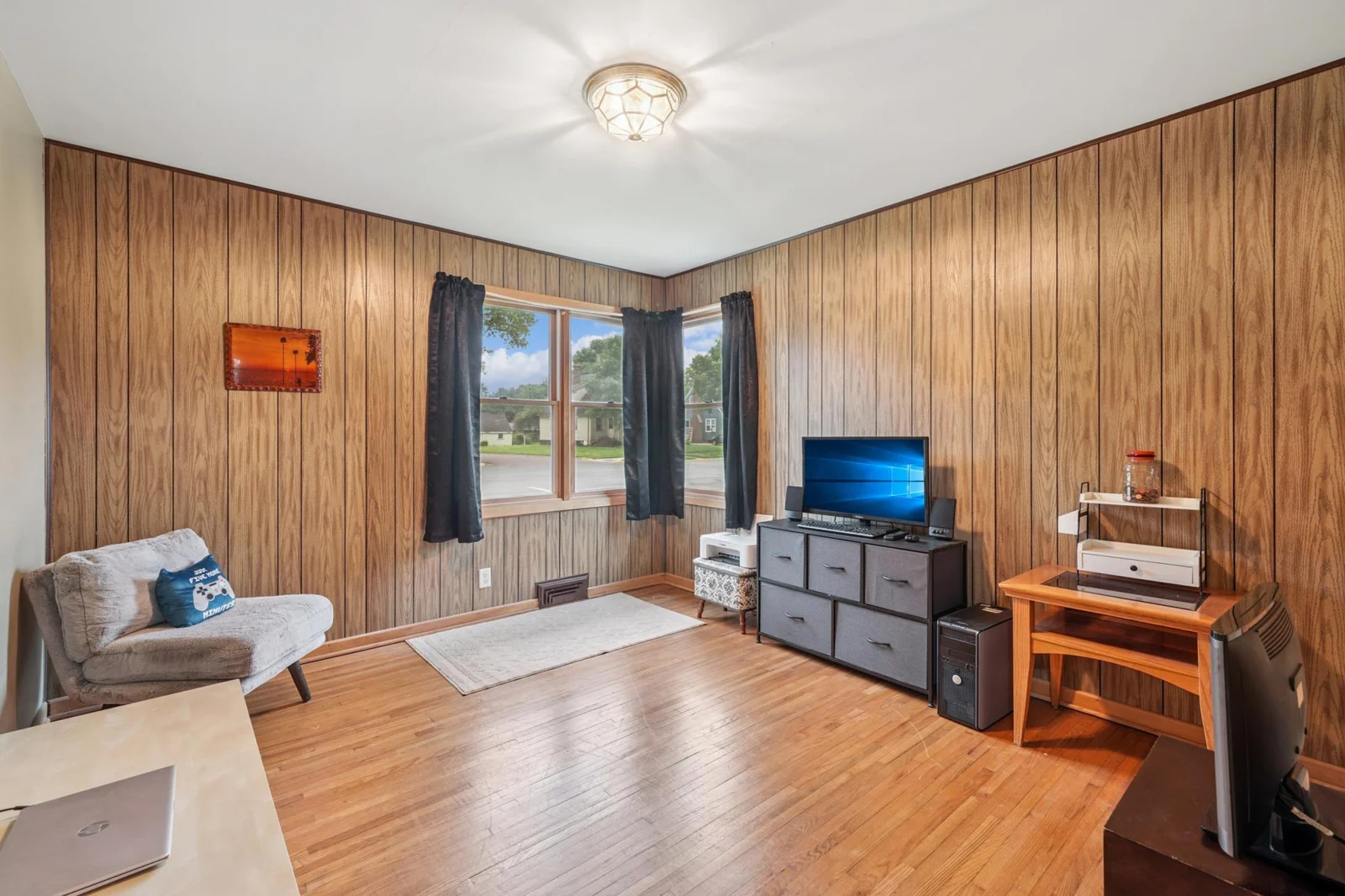 The second bedroom on the main floor features hardwood flooring. This room is currently being used as a den.