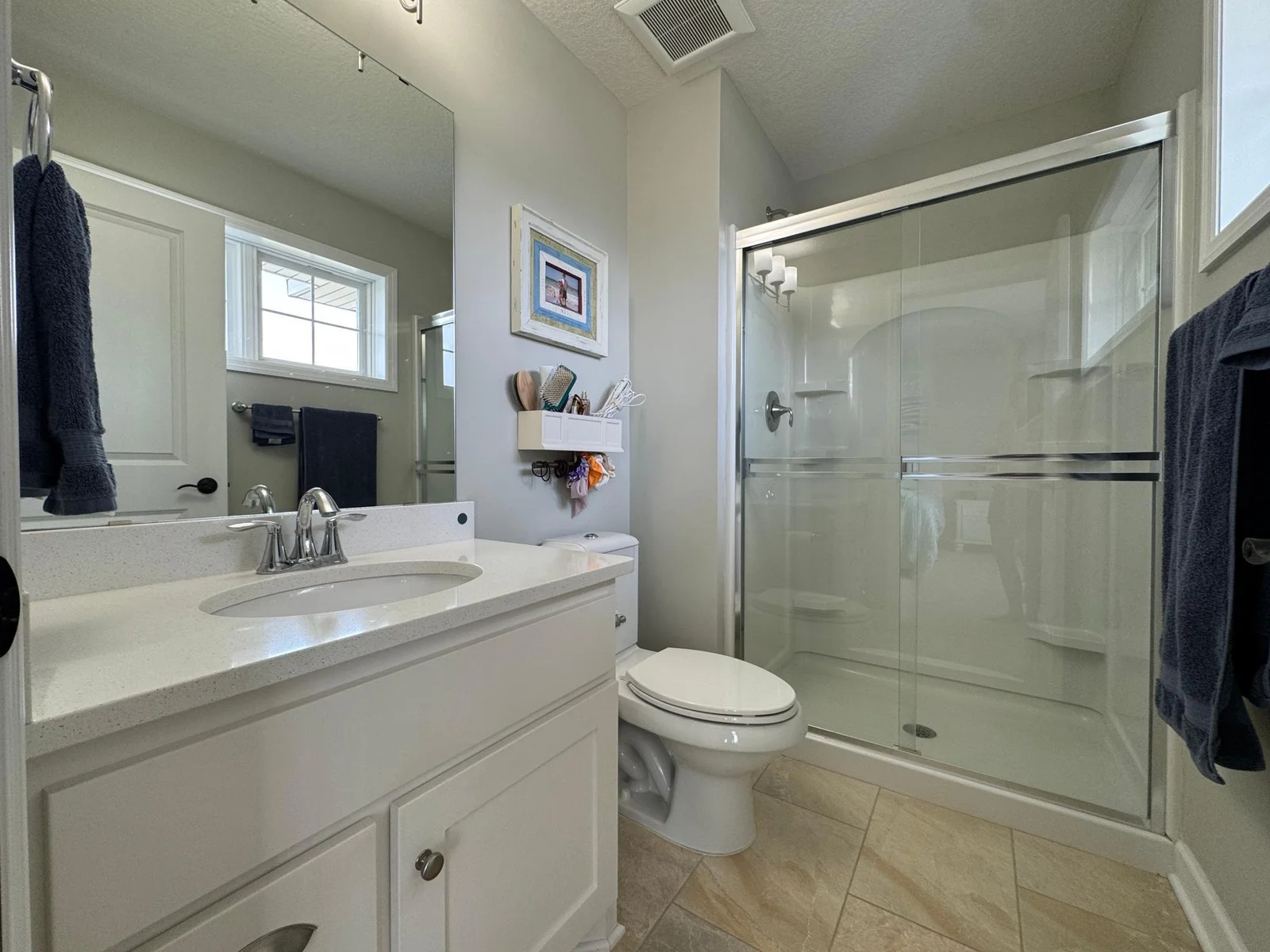 Tile floor, upgraded vanity/counter top and lots of natural light make this en-suite bathroom a wonderful place for family or guests to begin and end each day.