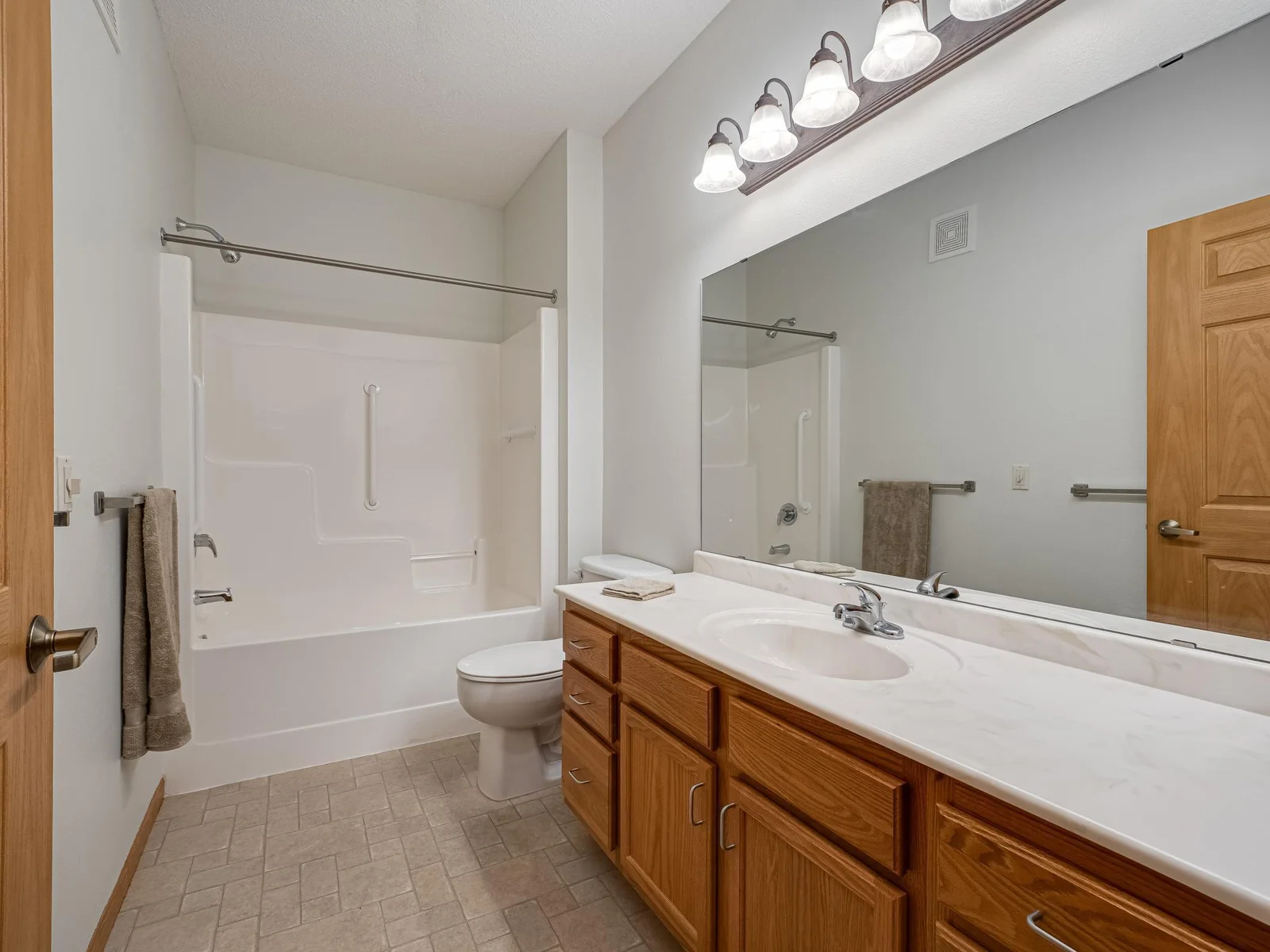 Main bathroom with full tub and grab bars.