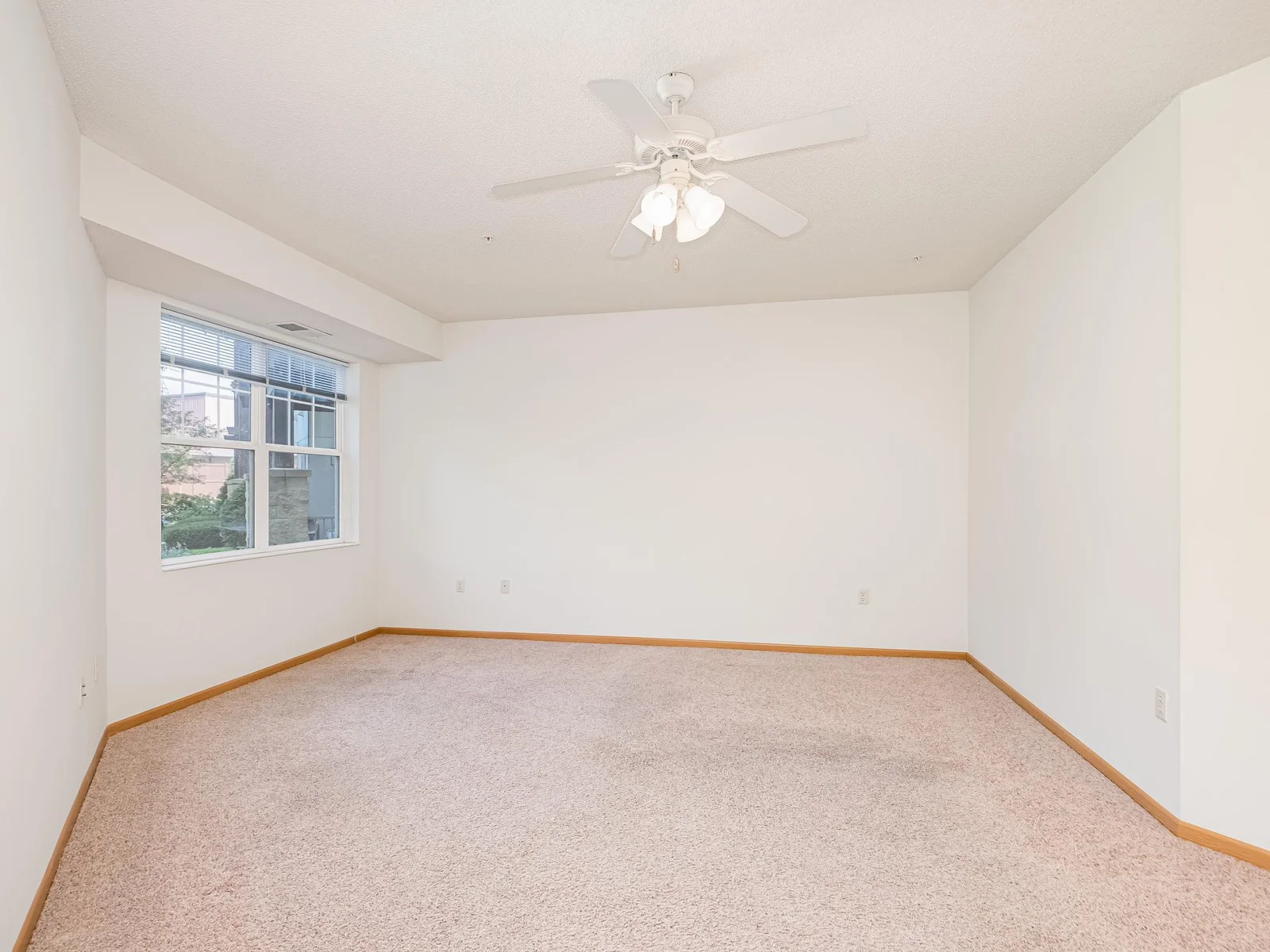 Large primary suite un-staged.  Features courtyard view and ceiling fan!