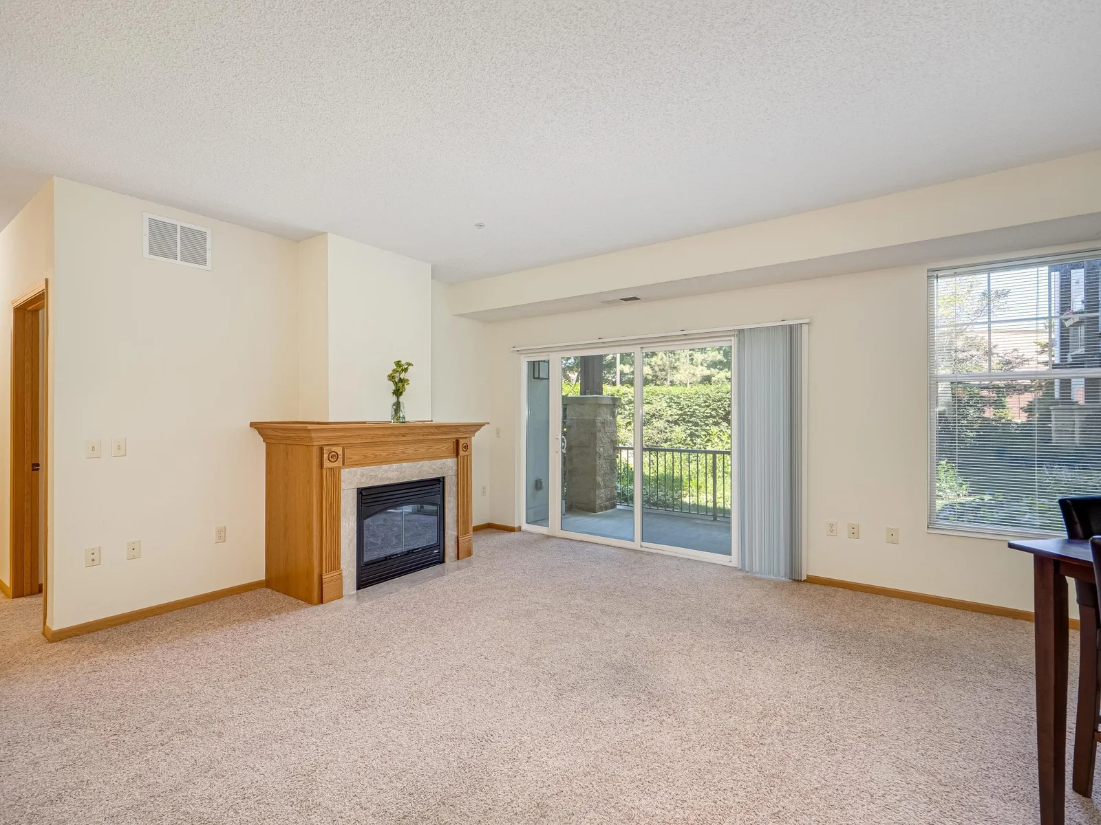 Un-staged living room. Easy access to the courtyard patio! Cozy electric fireplace adds ambiance.
