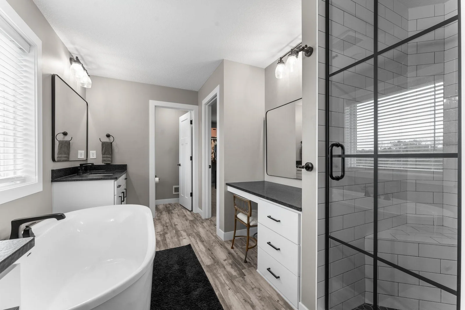 The private full bathroom is a spa-like retreat with an oversized soaking tub, walk-in tile shower, double vanities, and a vanity area with storage. It connects to the spacious walk-in closet, which leads to the upper-level laundry room.