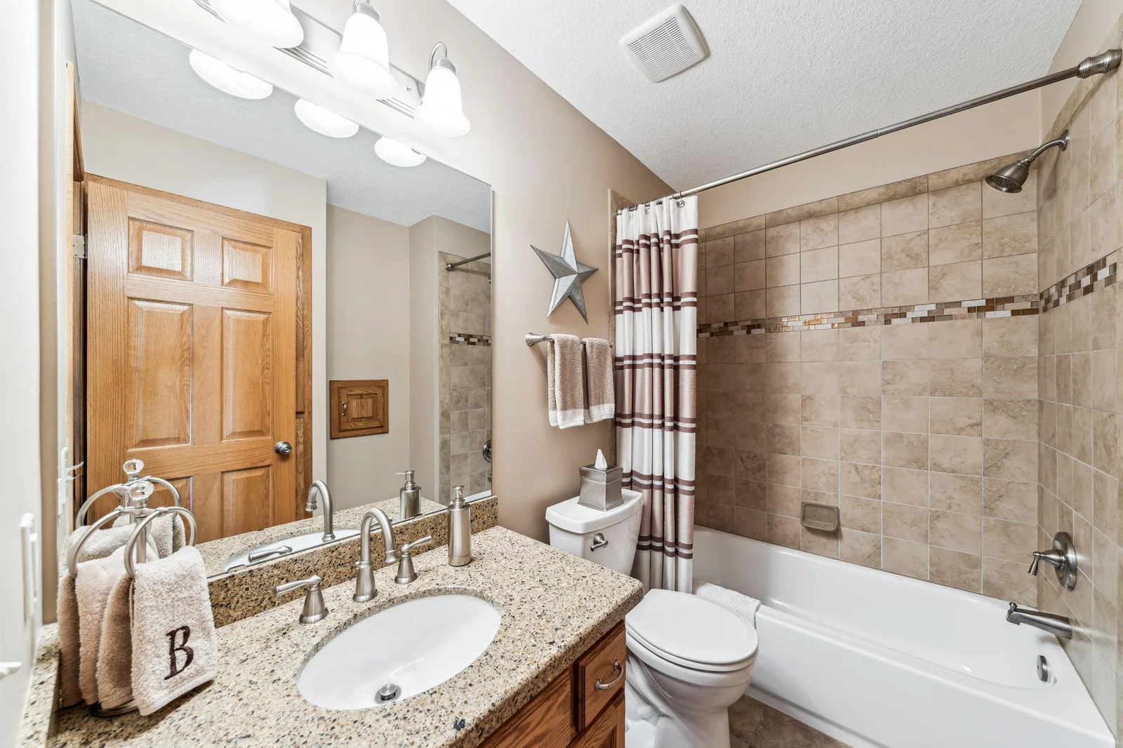Full bathroom with custom tile work and Cambria countertop.