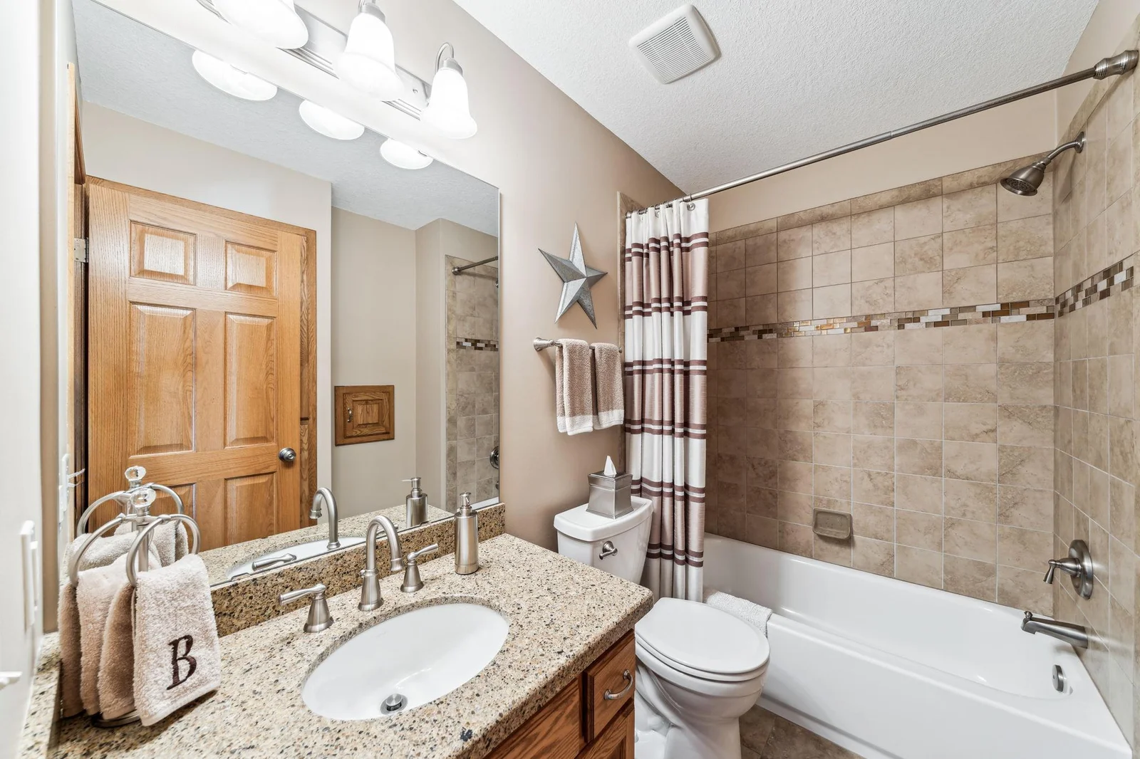 Full bathroom with custom tile work and Cambria countertop.