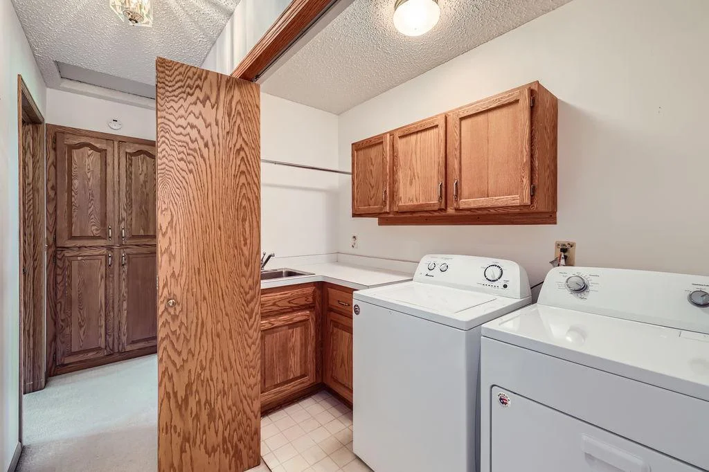 Handy Main Floor Laundry area with a sink, folding area and extra cabinetry.