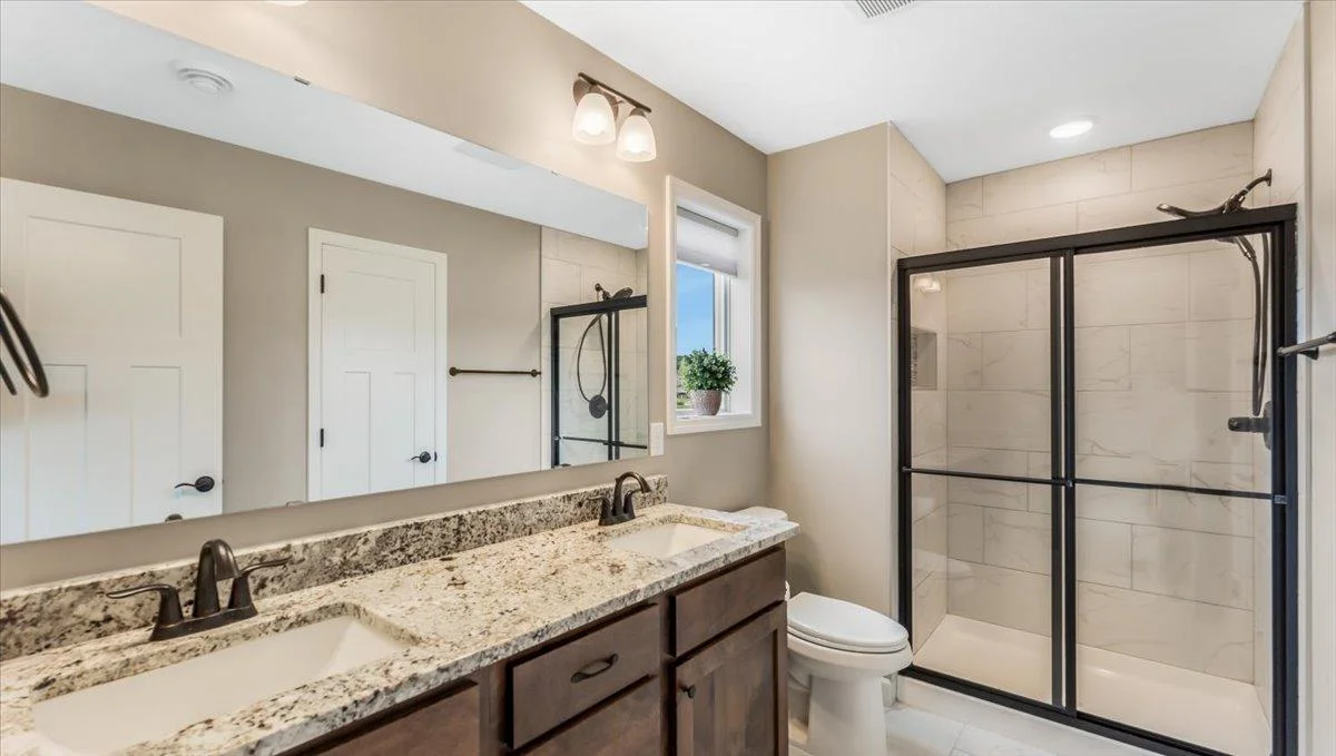 Modern 3/4 bathroom with a glass shower and large double vanity for an easy morning routine.